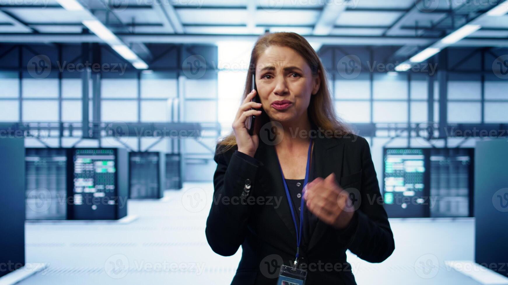 Technician in data center talking in phone call, doing yearly inspection. On field system administrator talking with manager in server hub during telephone call, monitoring servers, camera B photo