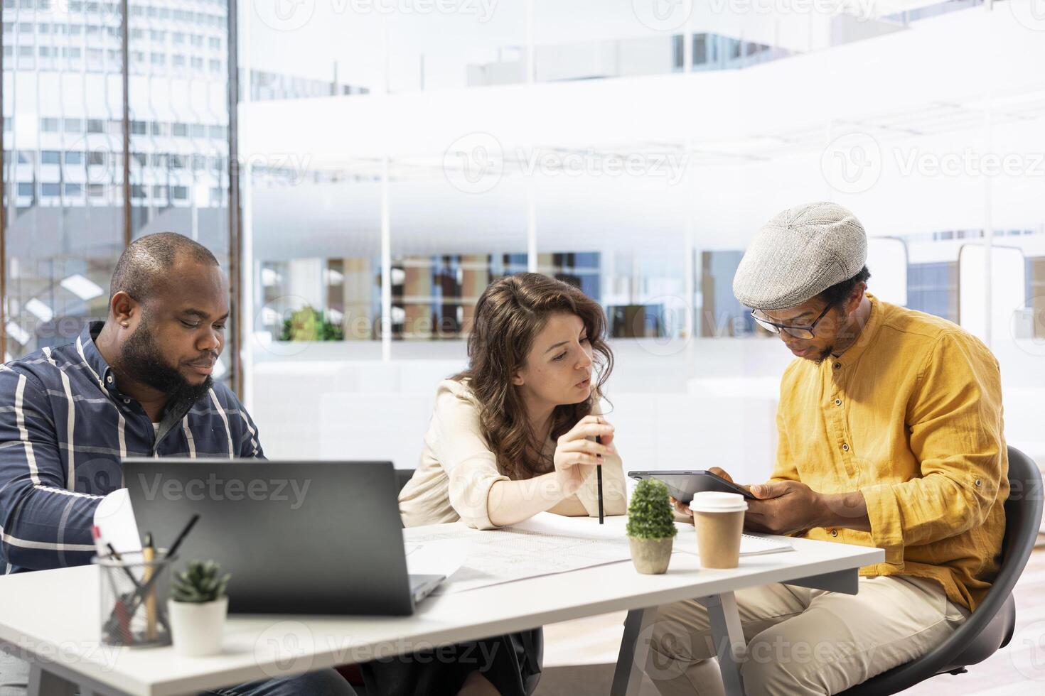 Corporate clients and their real estate agent examining blueprints and plans before agreeing to contract terms and investing in property. Discussing the layout of a new office space. photo