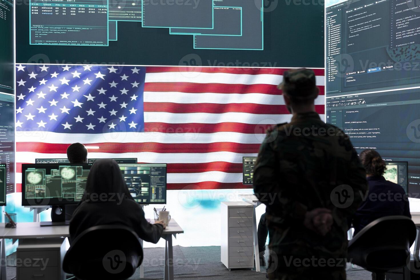 American army soldier working on servers and state secrets protection, safeguarding important hybrid war intelligence in high tech agency. Military official supervises hacking activity. photo