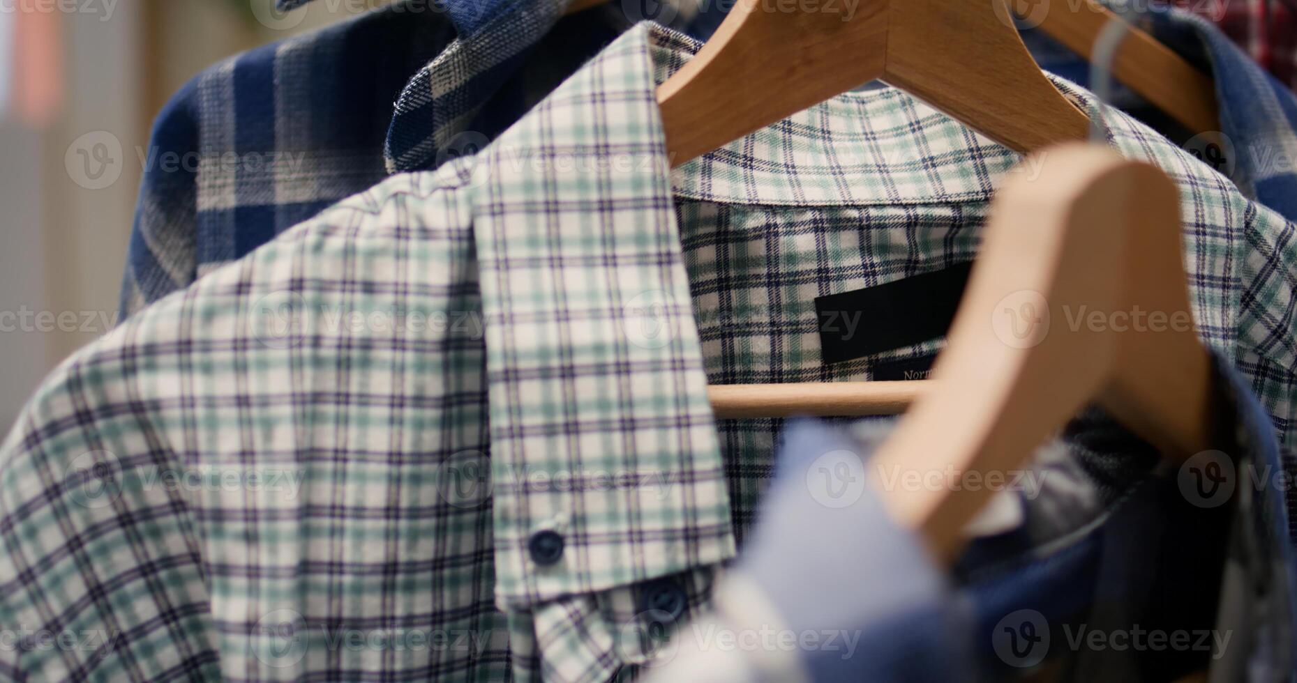 Extreme close up shot of high quality colorful shirts in thrift shop. Cozy and cheap casual men clothes in empty newly opened second hand fashion boutique awaiting customers photo