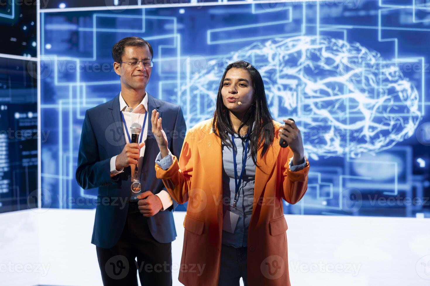 Presenter and guest chatting during AI summit discussion panel bringing together tech companies, exploring latest developments in artificial intelligence industry and emerging technologies photo