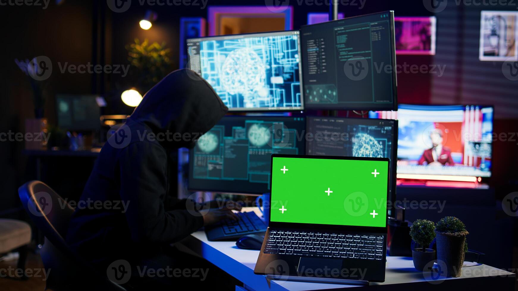 Hacker in hidden place using green screen laptop to deploy malware on unsecured devices, stealing sensitive data from unaware users online and selling it on black market, camera B photo