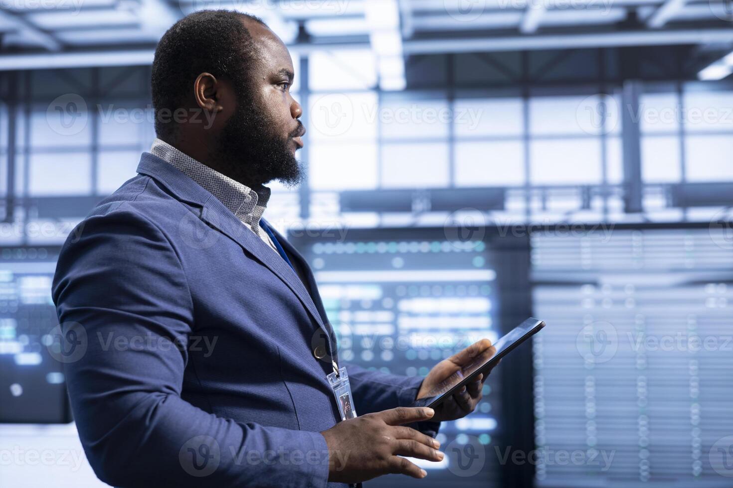 System administrator in data center checking rigs and hardware, doing checkup. Professional planning and executing high tech server hub facility migrations and upgrades using tablet photo