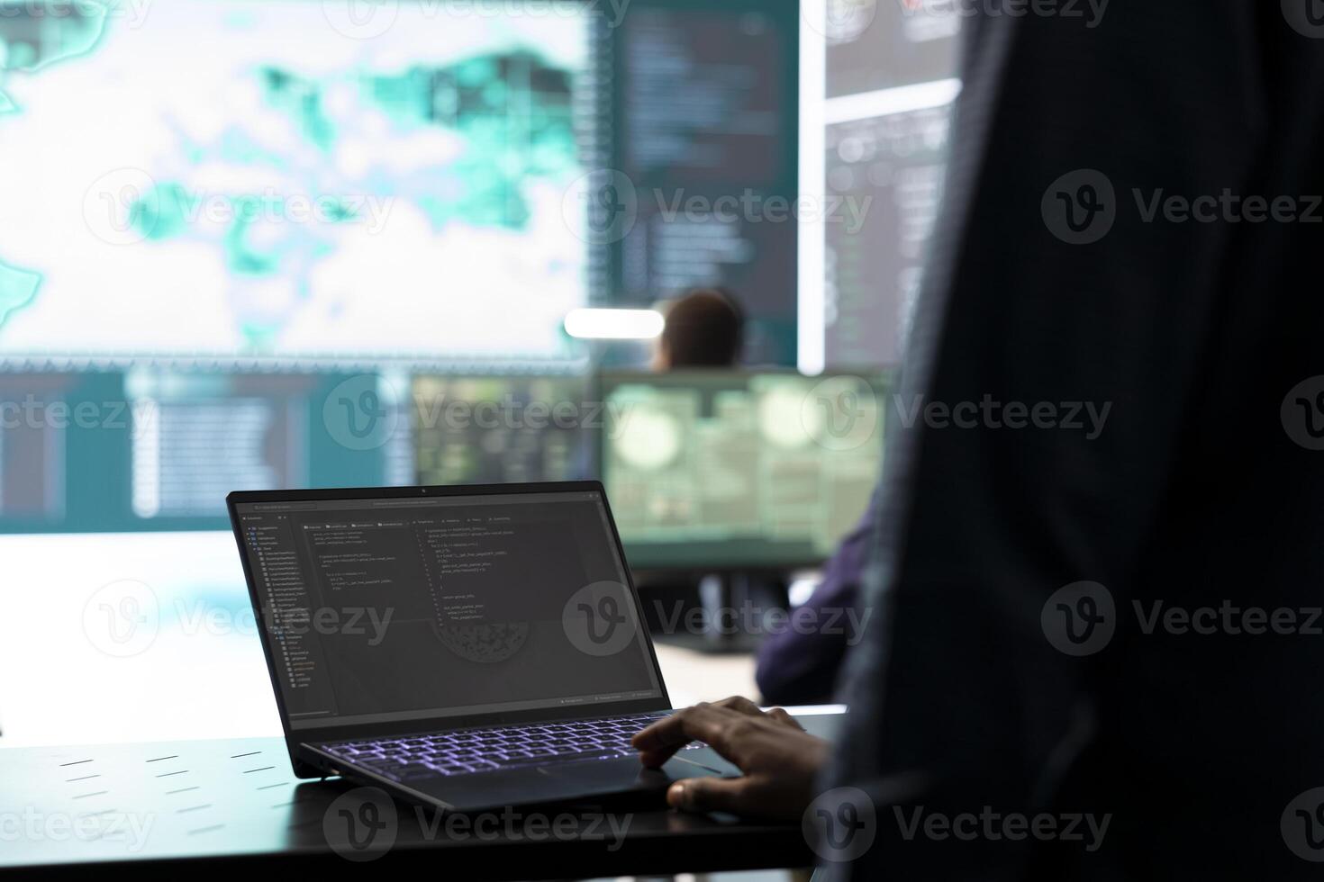 Governmental IT expert examines cyber threats on big screen and laptop, managing database hacking activity in high tech agency. Work on cyber defense to protect state secrets and networks. photo
