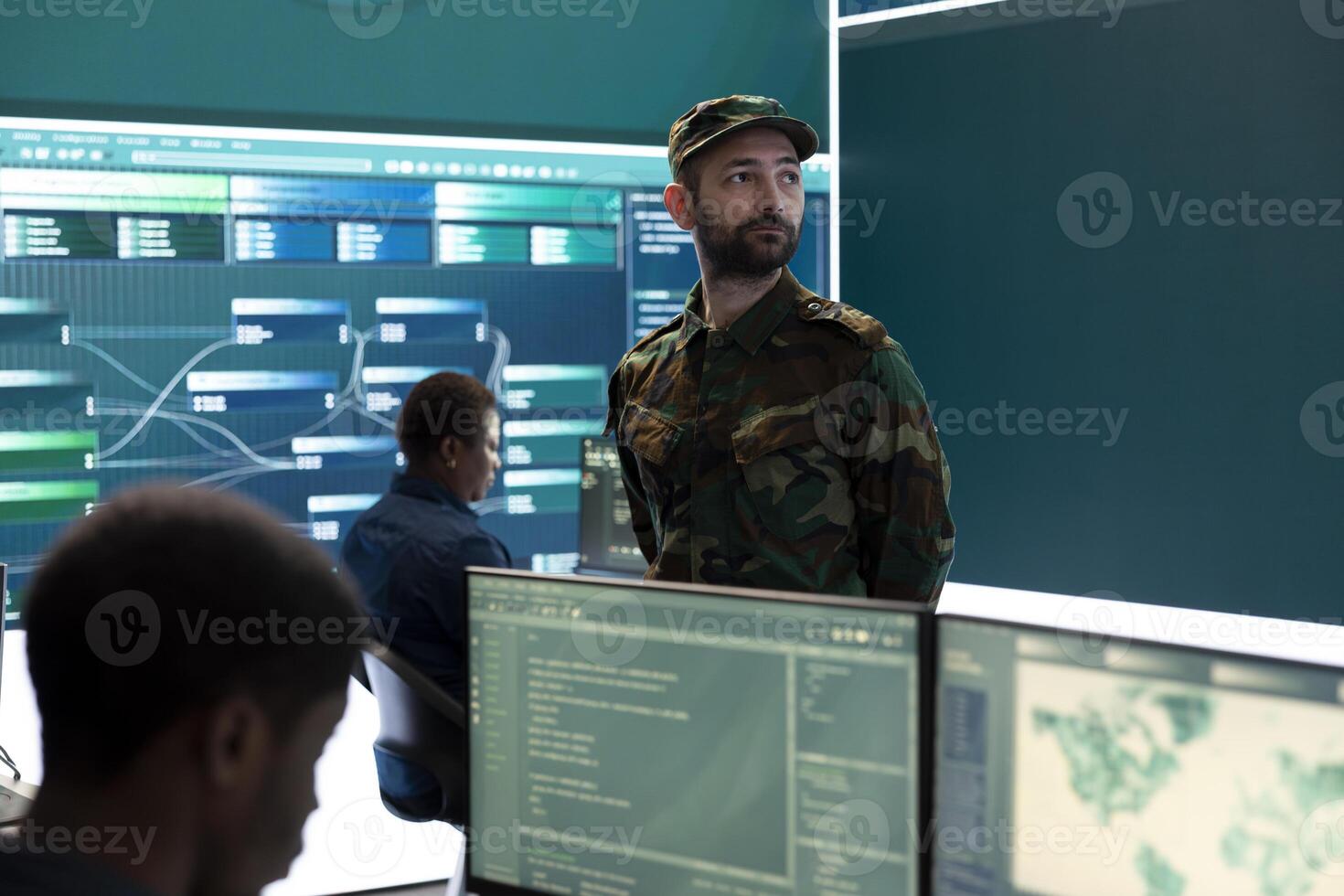 Military IT experts conducting surveillance and espionage activities using advanced technology and big screen. Governmental agency protecting against cyber threats and digital mercenaries. photo