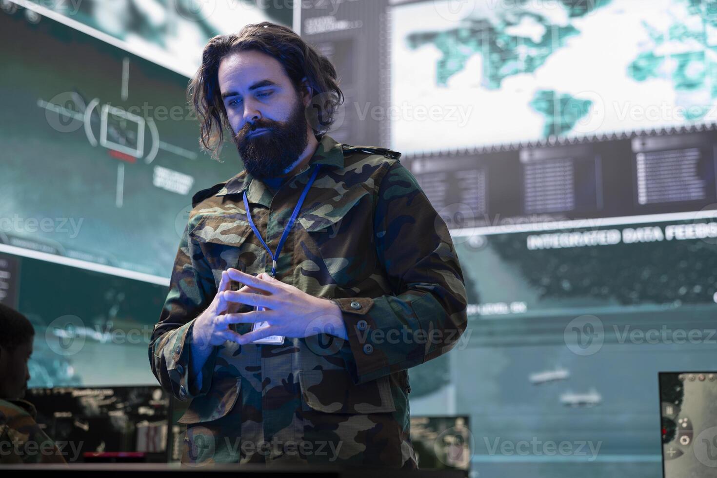 Army soldier reviewing information on a hologram projection in control center, creating a battlefield map for the infantry unit deployed. Serviceman monitoring surveillance system. photo