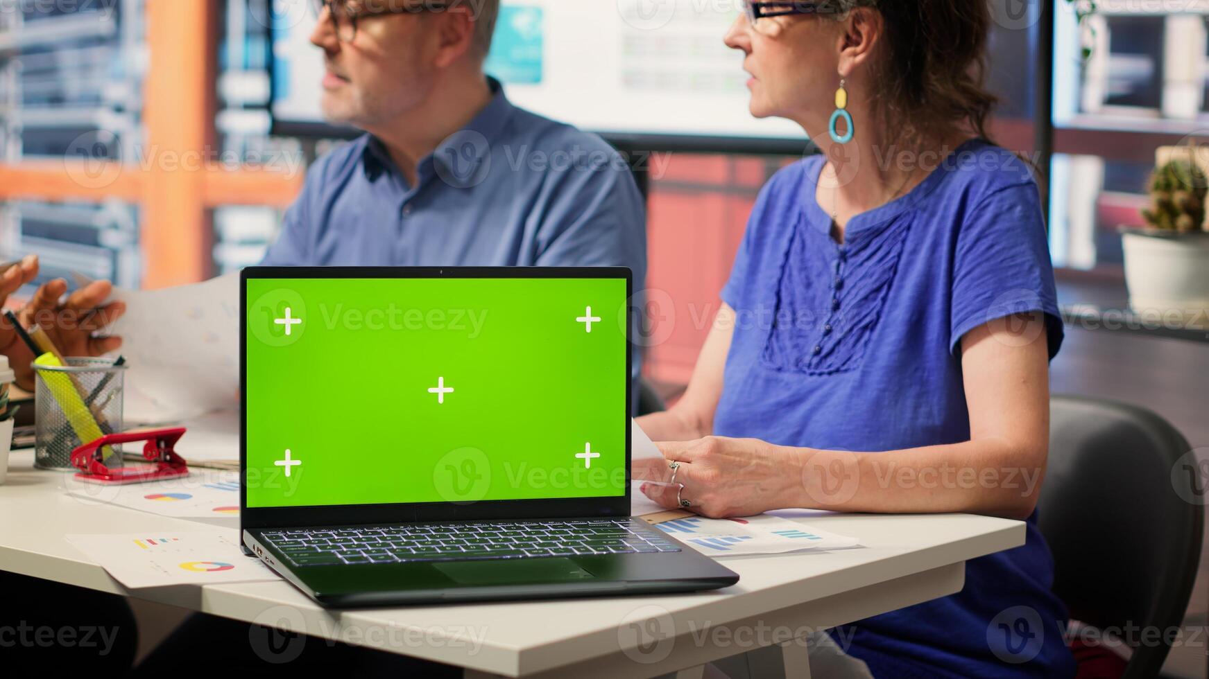 Elderly clients discussing with advisor about securing a pension plan, having a chroma key on laptop in modern office. Senior people establishing a retirement option for life insurance. Camera A. photo
