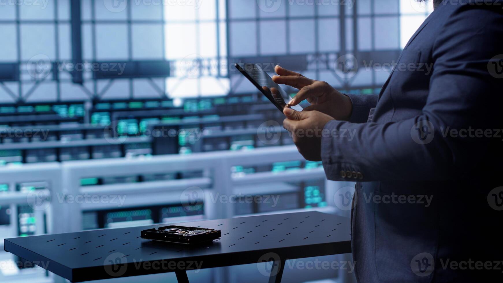 Technician in server hub workplace installing newly ordered storage unit, checking parameters with tablet. IT expert in data center holding device, replacing storage mainframes components, camera A photo