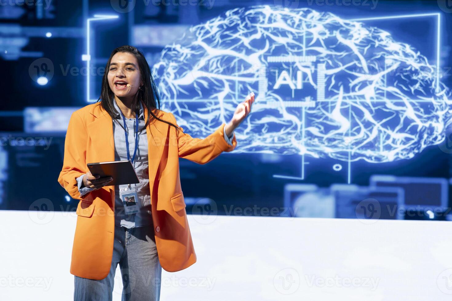 Cheerful manager holding tablet speaking at event bringing together leading researchers to explore developments in AI and machine learning. Smiling professional using device to hold tech presentation photo