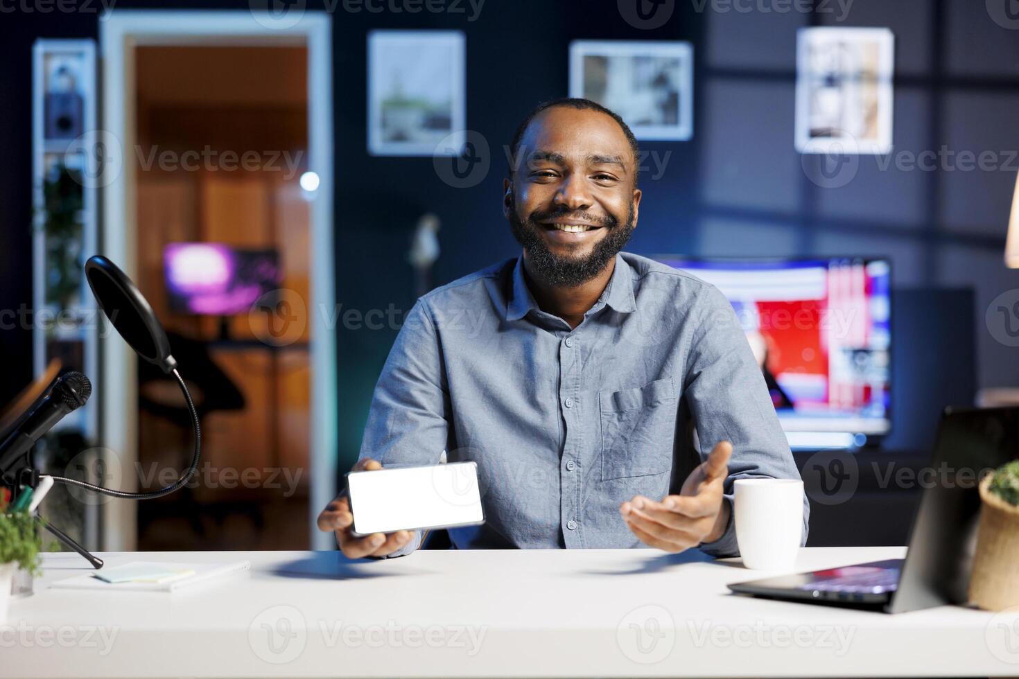 BIPOC online star being sponsored by partnering brand to do mockup cellphone unboxing content. Excited tech specialist does influencer marketing, presenting isolated screen phone device photo