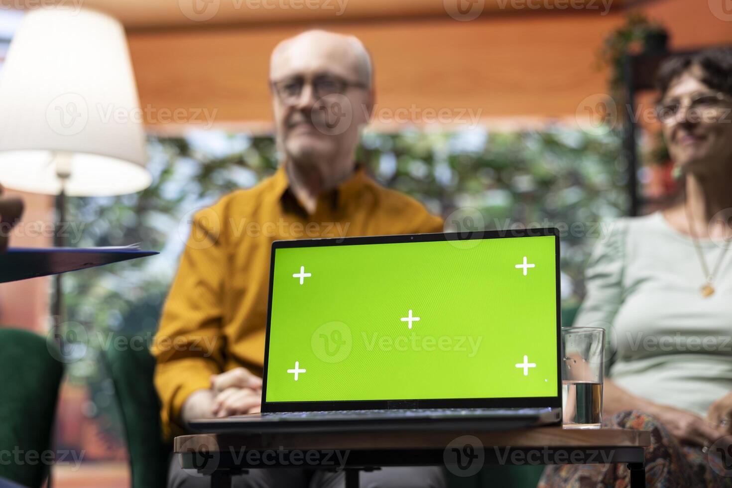 Social caretaker visiting elderly people patients at their home, using isolated mockup and doing a consultation to give treatment and vitamins for wellness. Nurse talking to old couple. photo