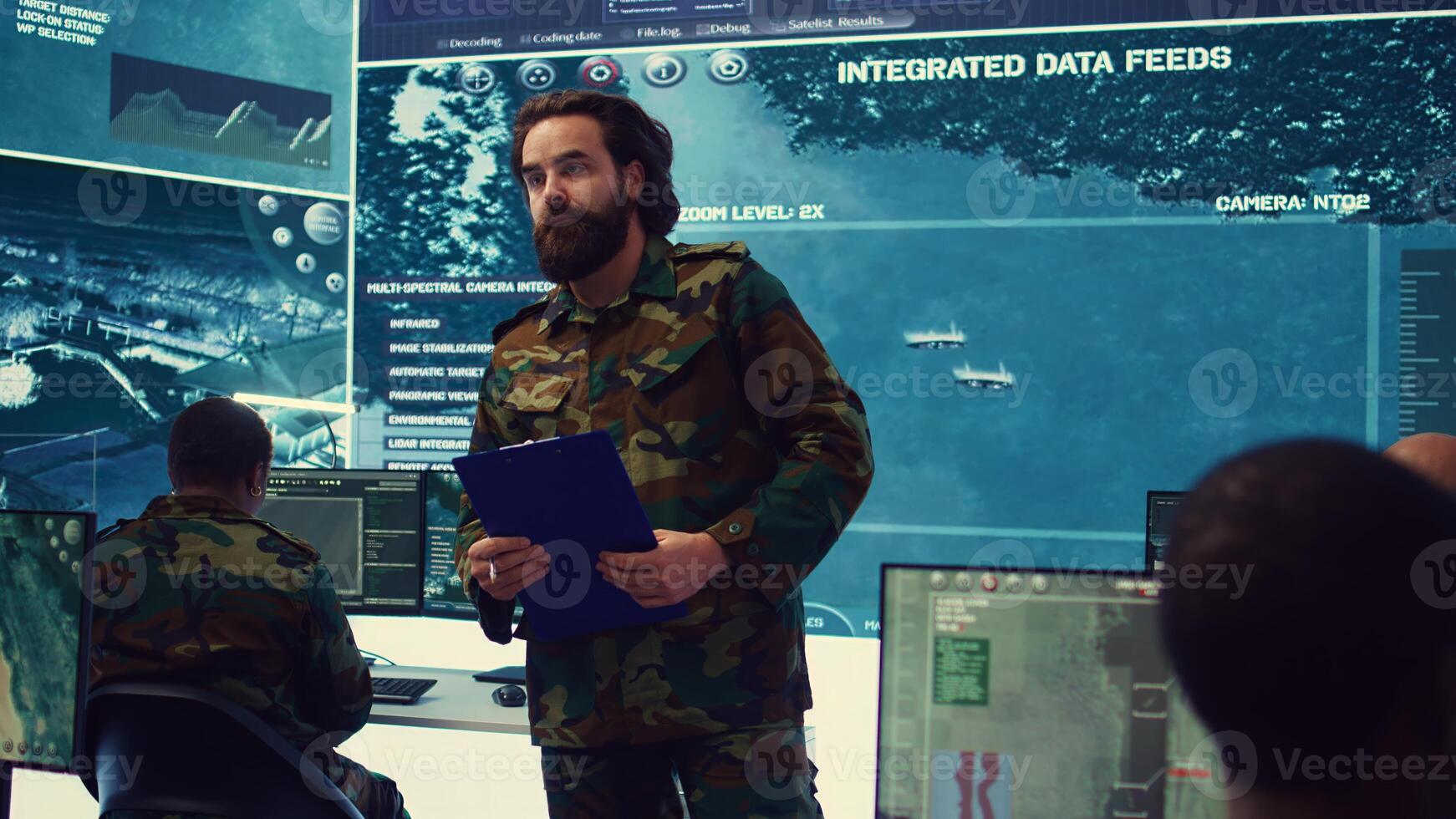 Army general manages and interprets satellite footage to gain insight targeting enemy positions. Marine corps officer takes notes about hostile vessels trajectory, national safety. Camera B. photo
