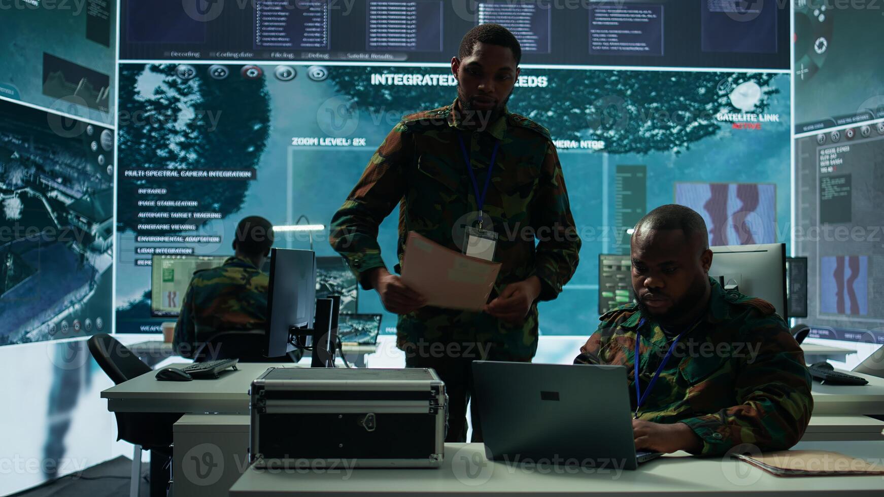 Intelligence agents in modern operations center managing surveillance activity and synchronizing security protocols. Army base staff interpret real time data to protect national interests. Camera B. photo