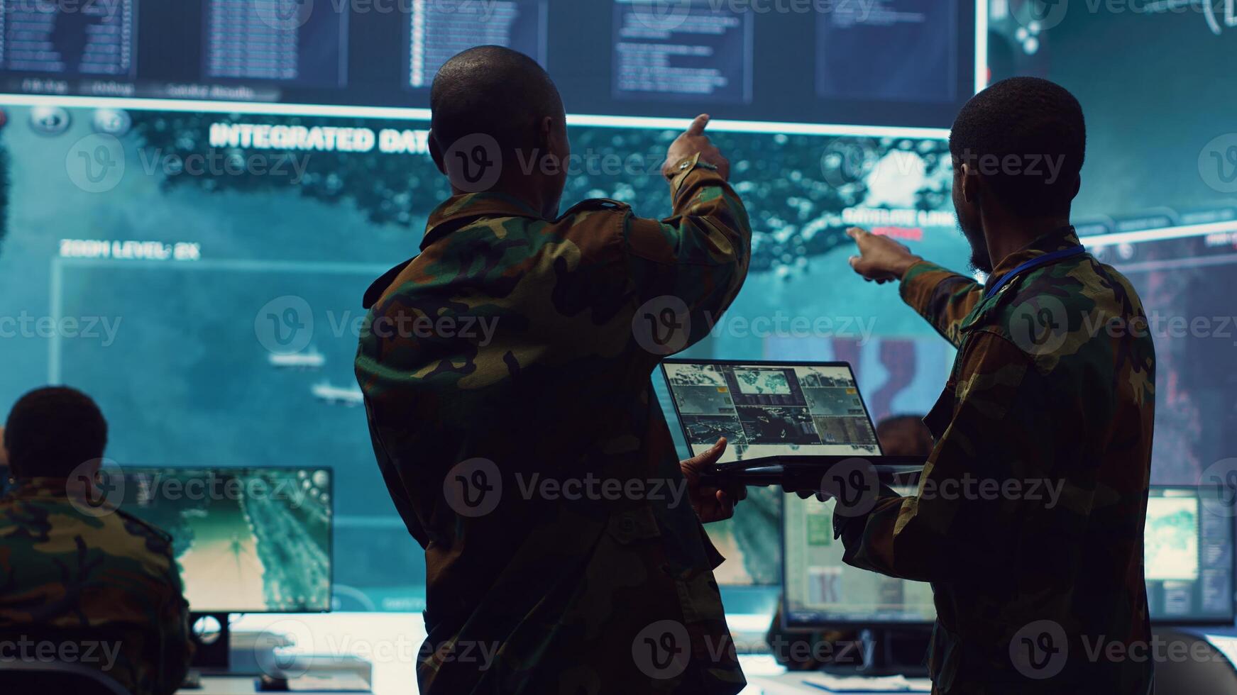 Intelligence analysts supervising and coordinating the big data analysis, processing tactical information to help the field troops. Officers monitoring real time warfare information. Camera A. photo