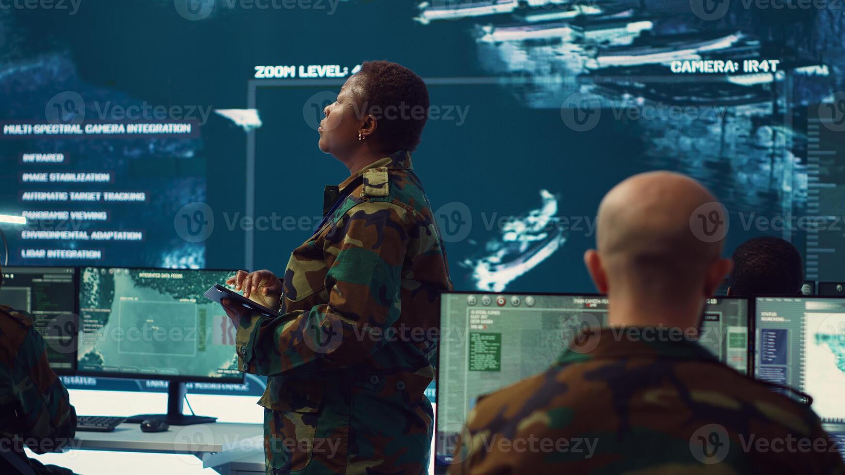 Female brigadier general conducing anti terrorism mission in military operations room, employing radar systems to detect and track enemy aircraft or missiles. Secret service program. Camera A. photo