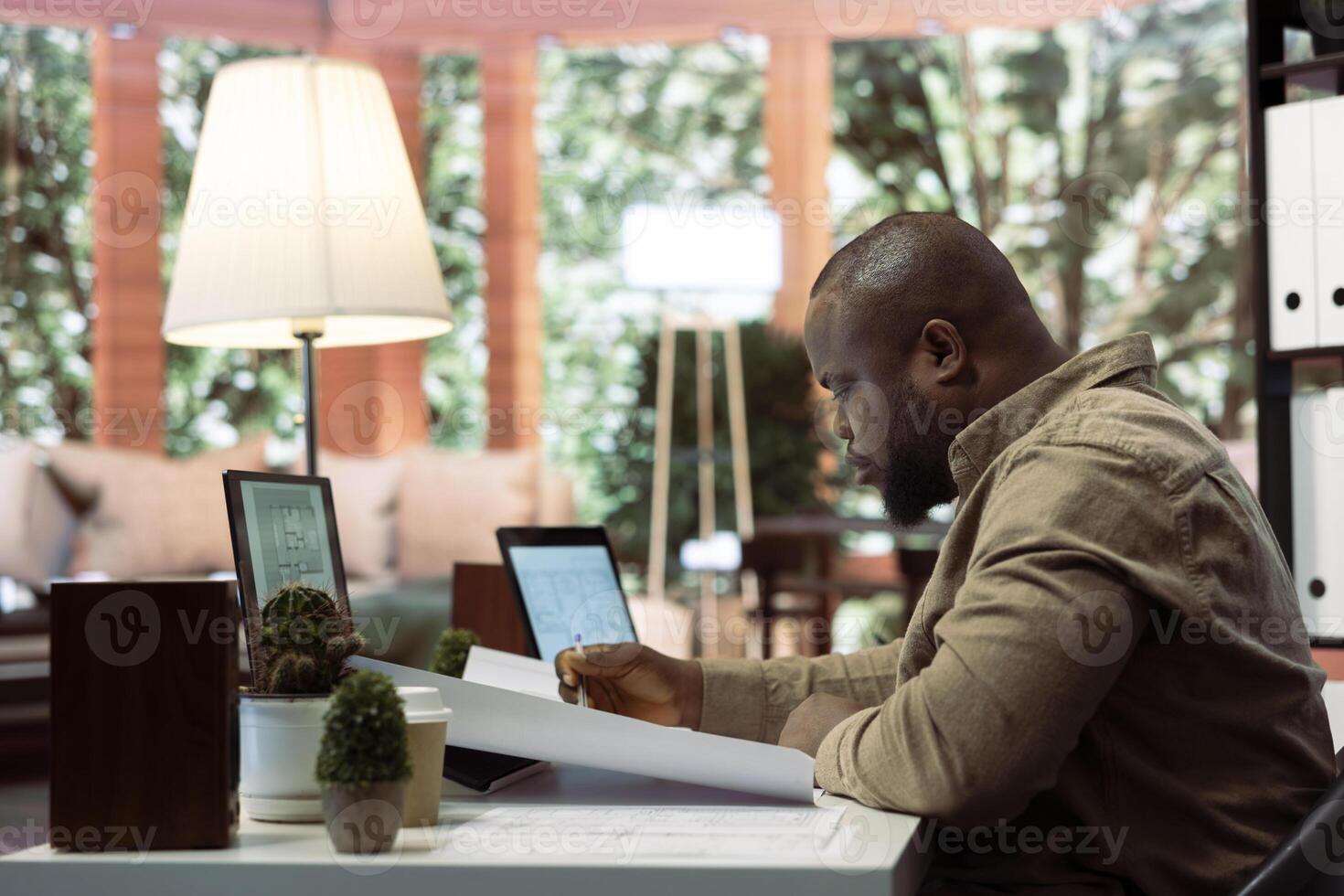 Corporate owner measuring and evaluating office blueprints and architectural sketches, working on strategy planning for a modern and professional workspace design. Relocate office space. photo