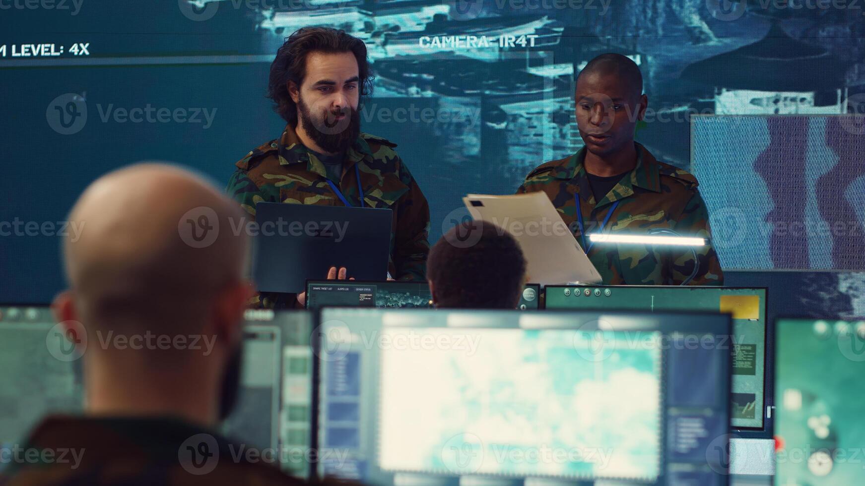 Crew captain and general briefing the troops in military headquarters command center, operating with a big screen to follow CCTV reconnaissance system. Soldiers collecting data. Camera A. photo