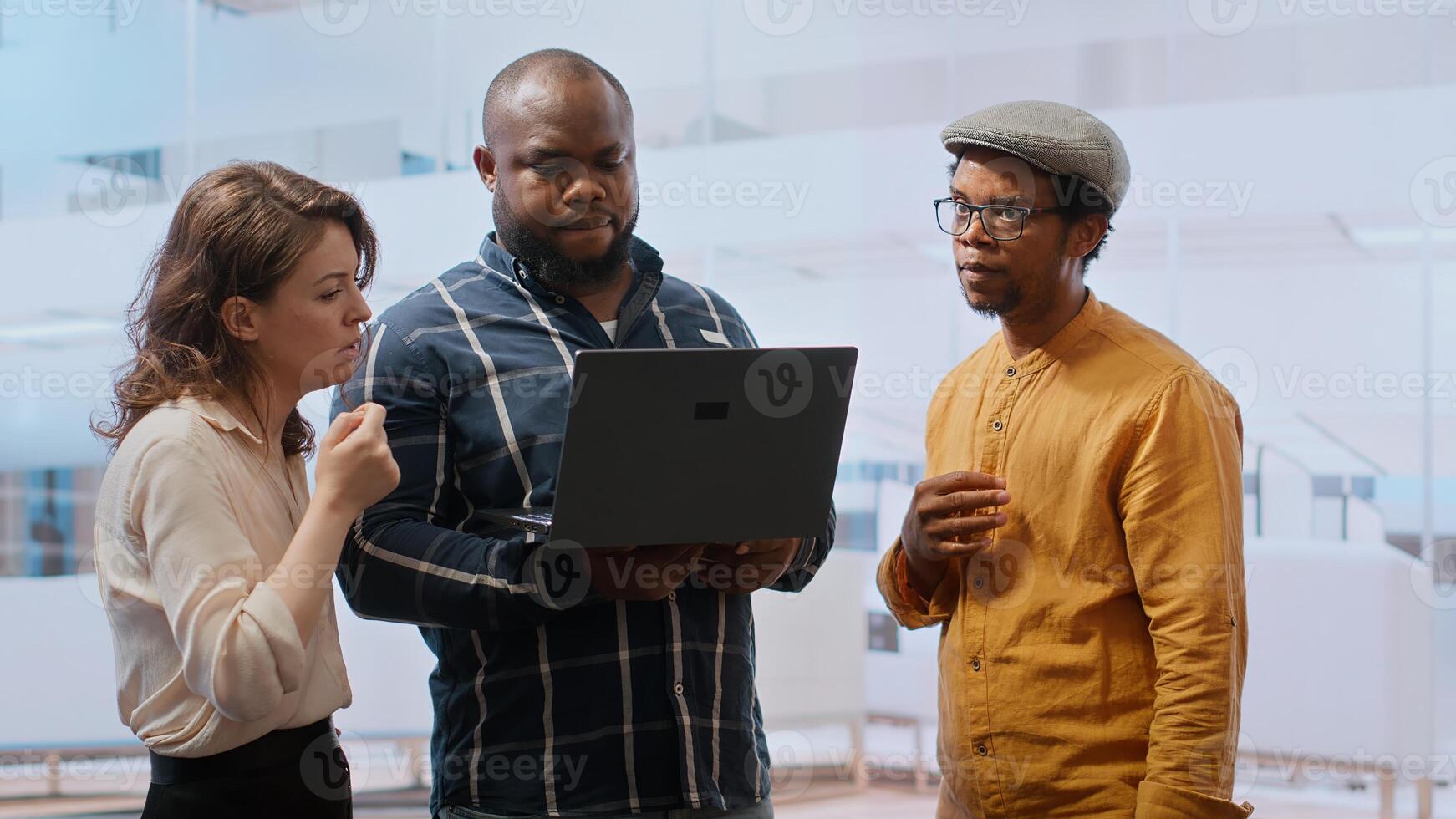 Real estate agent presenting a new office building to clients, discussing the detailed blueprints using a tablet during the property tour. Potential leasing investment opportunity. Camera B. photo