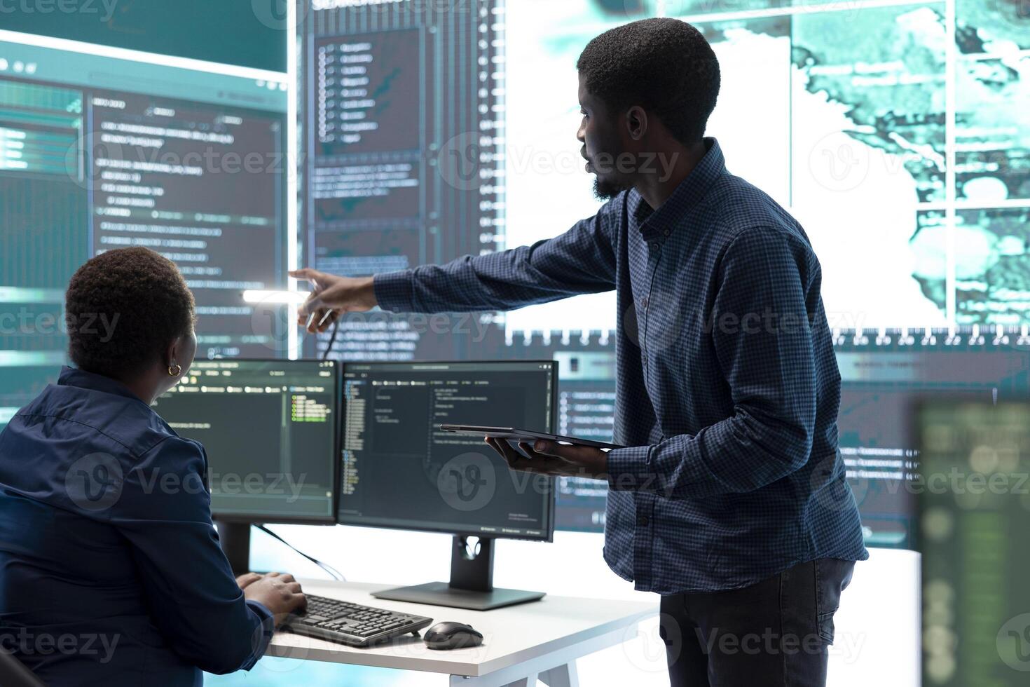 Cyber defense team working in a governmental security operations center. Experts ensuring cybercrime prevention and data breach protection, examining information on a big screen. photo