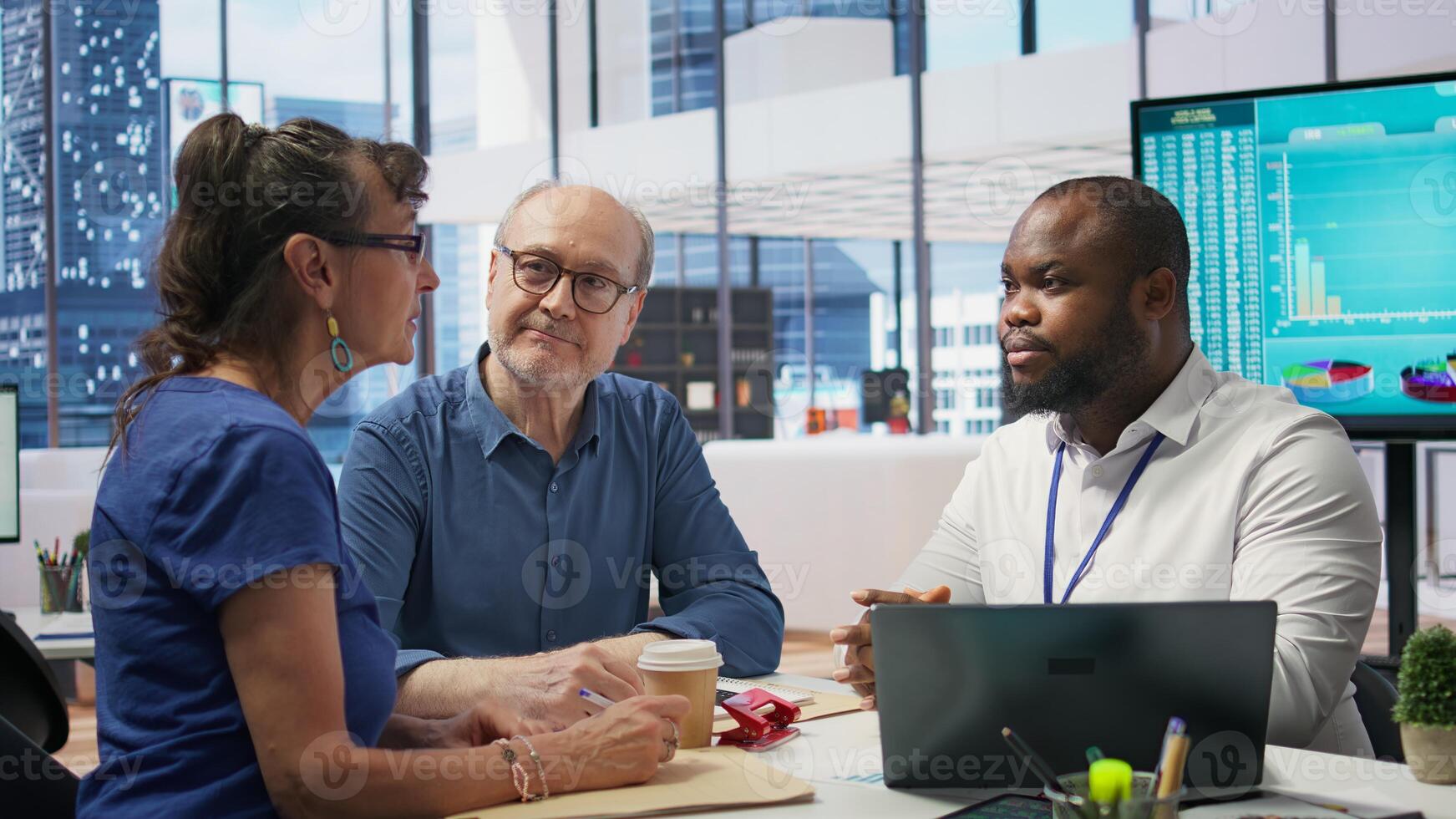 Middle aged people receiving financial advice on retirement planning and life insurance, focusing on increasing their savings with pension plans. Senior couple meeting with banker. Camera B. photo