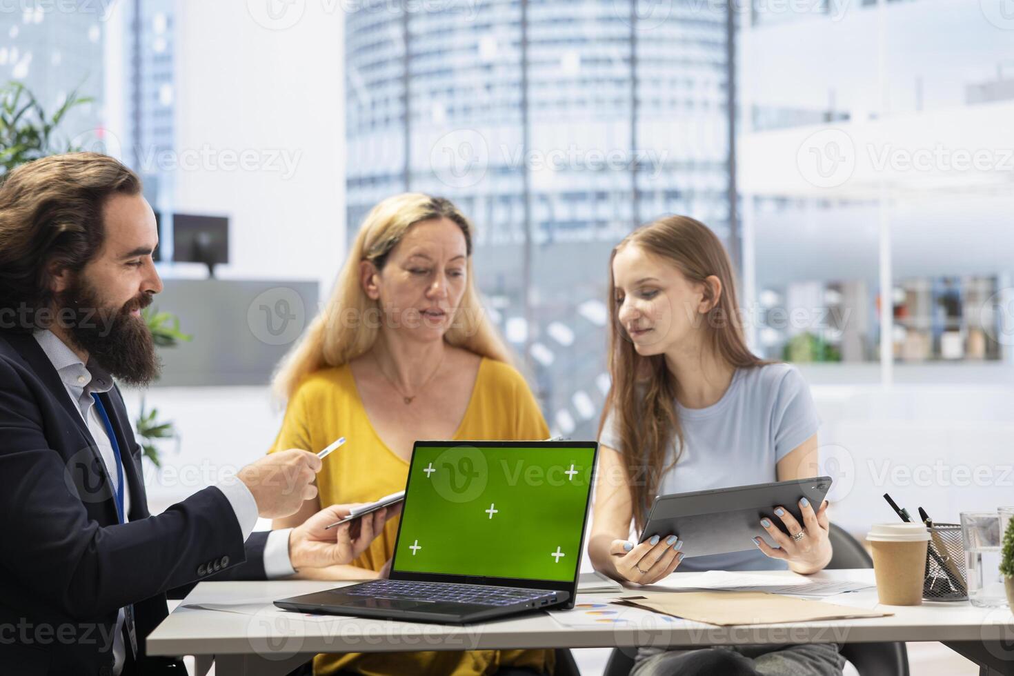 Financial advisor uses software on green screen laptop to calculate clients net worth, taking count of assets and liabilities. Agent uses mockup notebook to help family decide how much money to invest photo