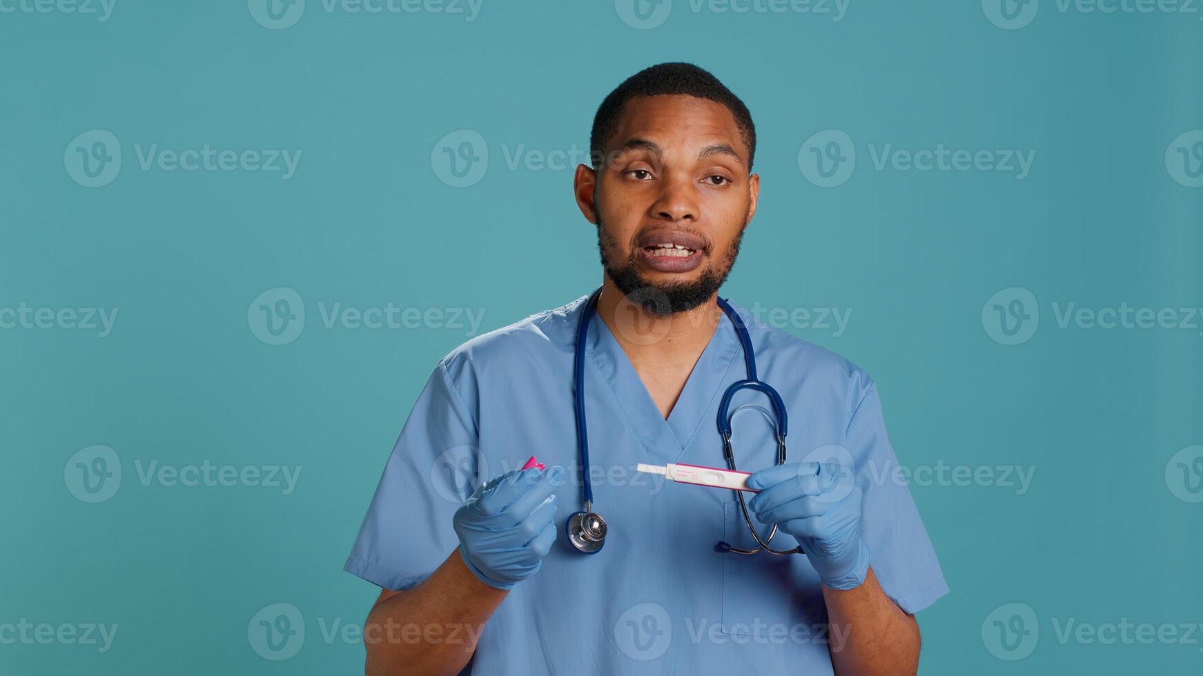 Portrait of doctor holding pregnancy test, doing instructional for parents awaiting kids, studio background. Healthcare professional doing tutorial on how to read pregnancy kit result, camera A photo