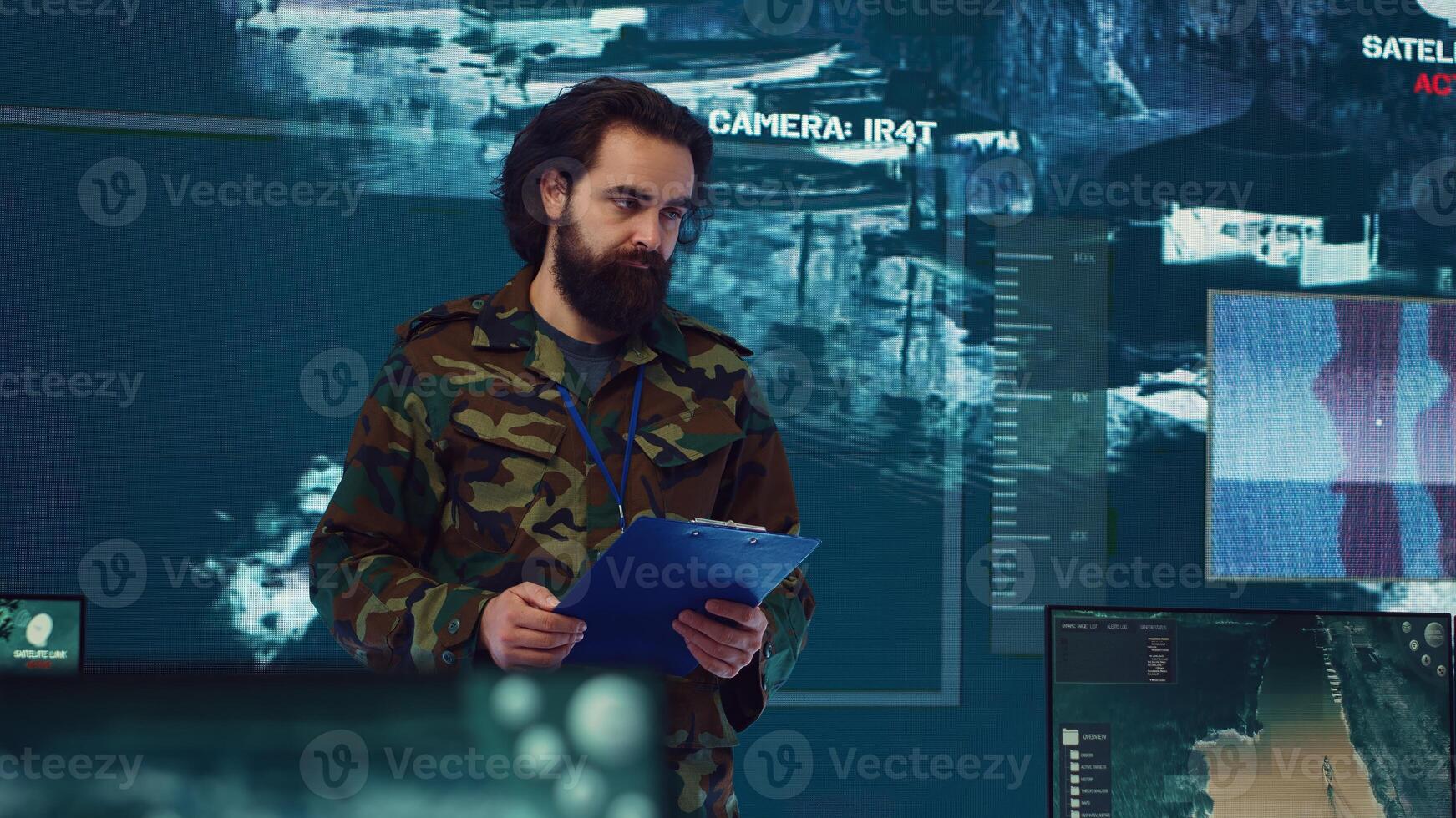 Infantry unit leader coordinating troops to execute special operations, briefing crew with mission details for national safety. Military commander studies real time surveillance data. Camera A. photo