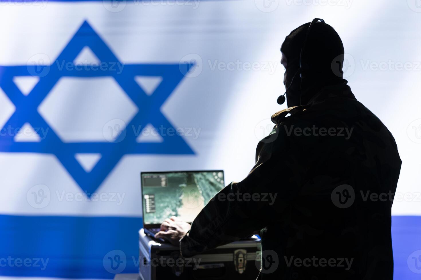 Mossad operative dispatcher talks in headphones mic, relaying surveillance data, standing isolated over Israel flag. Incognito intelligence operative completes mission during geopolitical operation photo