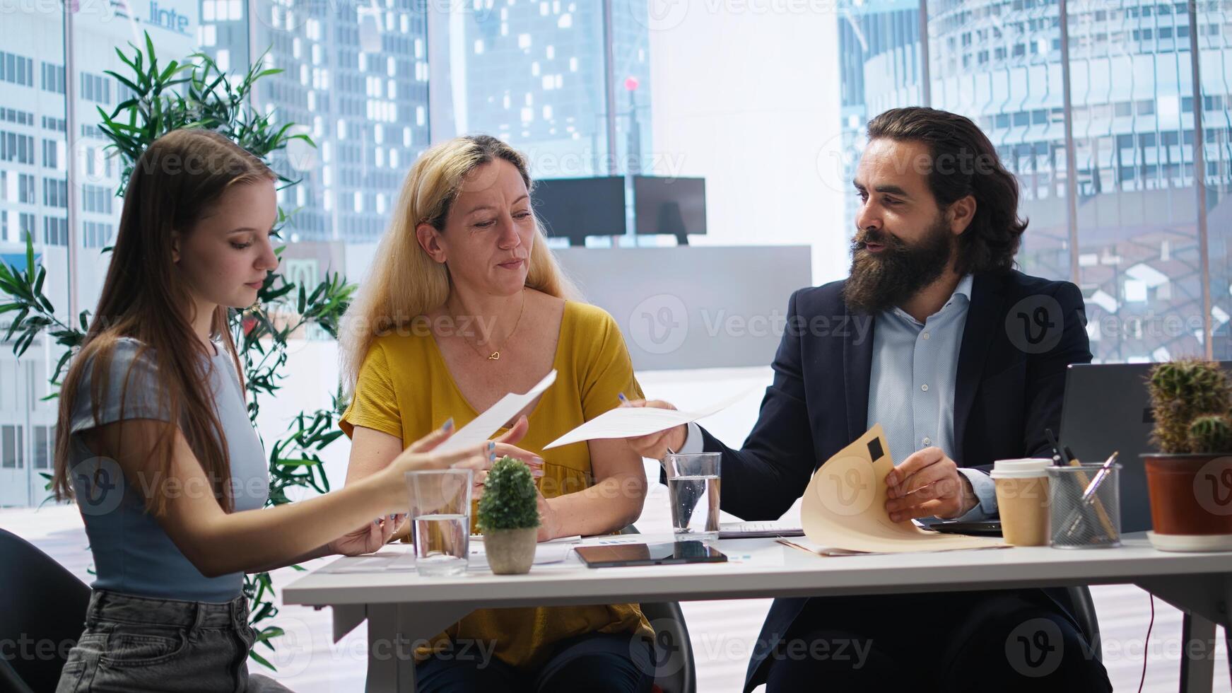 Financial advisors meeting with clients to counsel them on their finances and give them personalized financial plan. Agent guiding family in making profitable and secure decisions, camera A photo