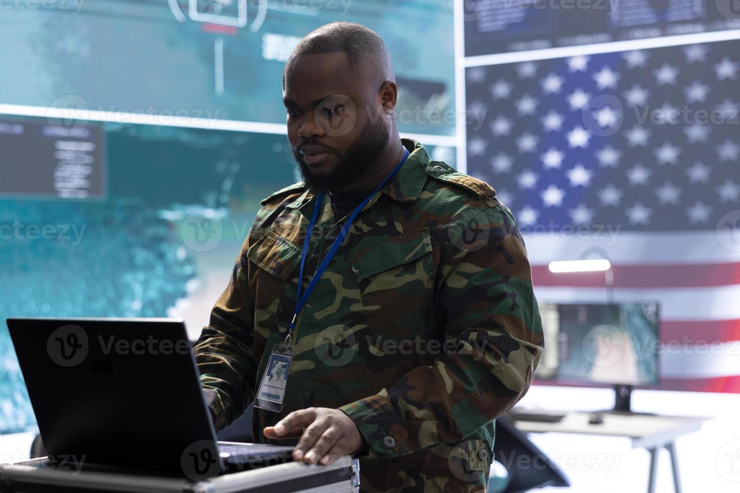 Military cybersecurity specialists manage data protection and gathering intelligence from cctv footage and a world map. Ensuring national security from a high tech US army command post. photo