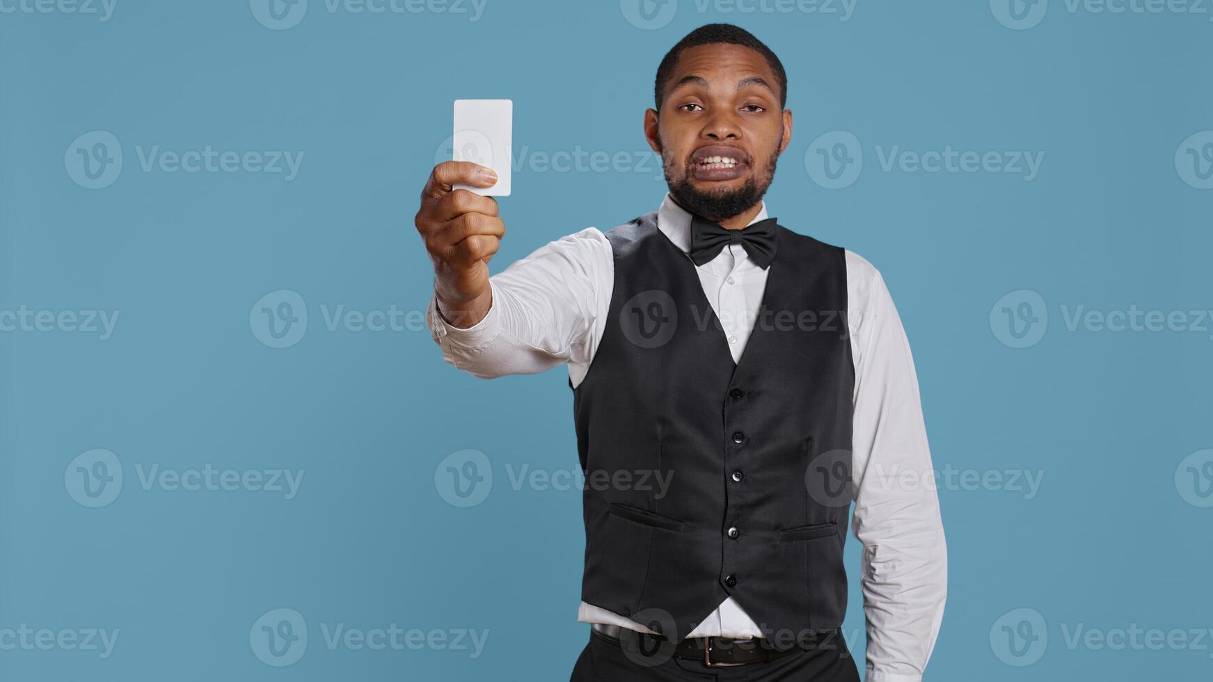 Bellhop personnel offering access card to the room for guests, presenting the key after check in procedure. Hotel porter employee providing lodging and five star amenities at the resort. Camera B. photo