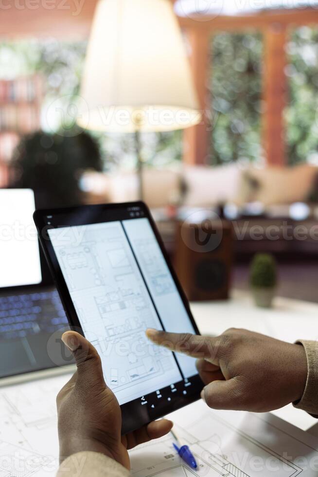 Small business owner evaluating office space blueprints and layouts for a relocation investment strategy, planning a professional workspace leasing. Drafting sketches at home desk. photo