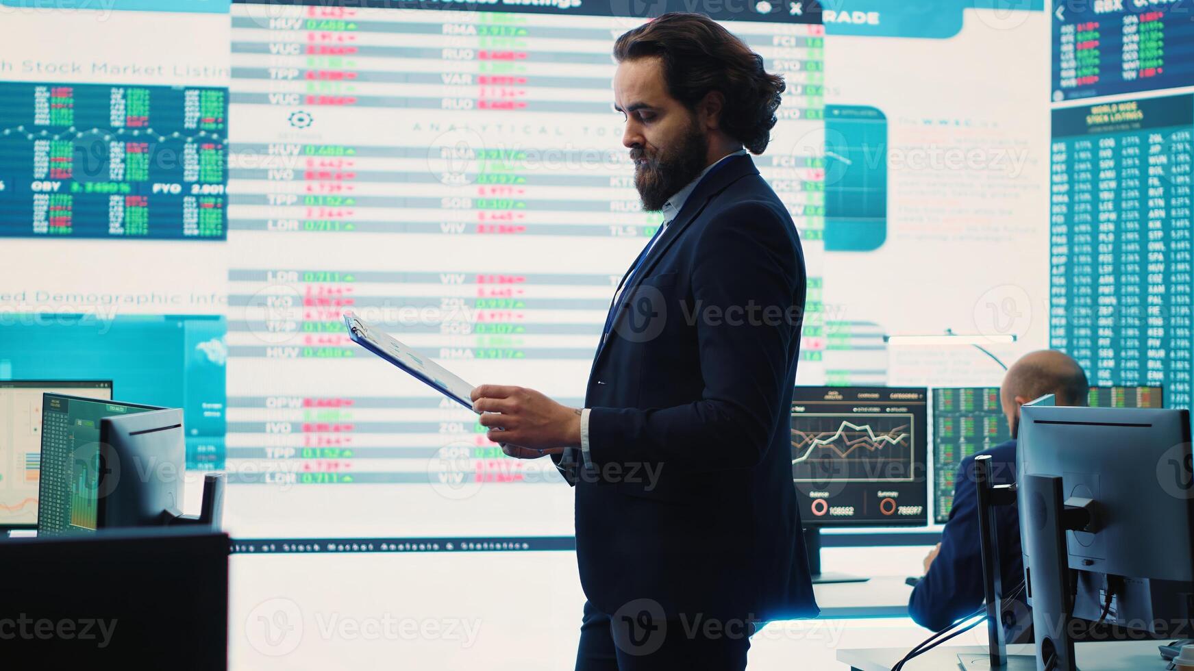 Chief executive officer reviews data shown on big display in the office, screens with infographics, finance analysis and organizational progress. Telecommunications system control room. Camera A. photo