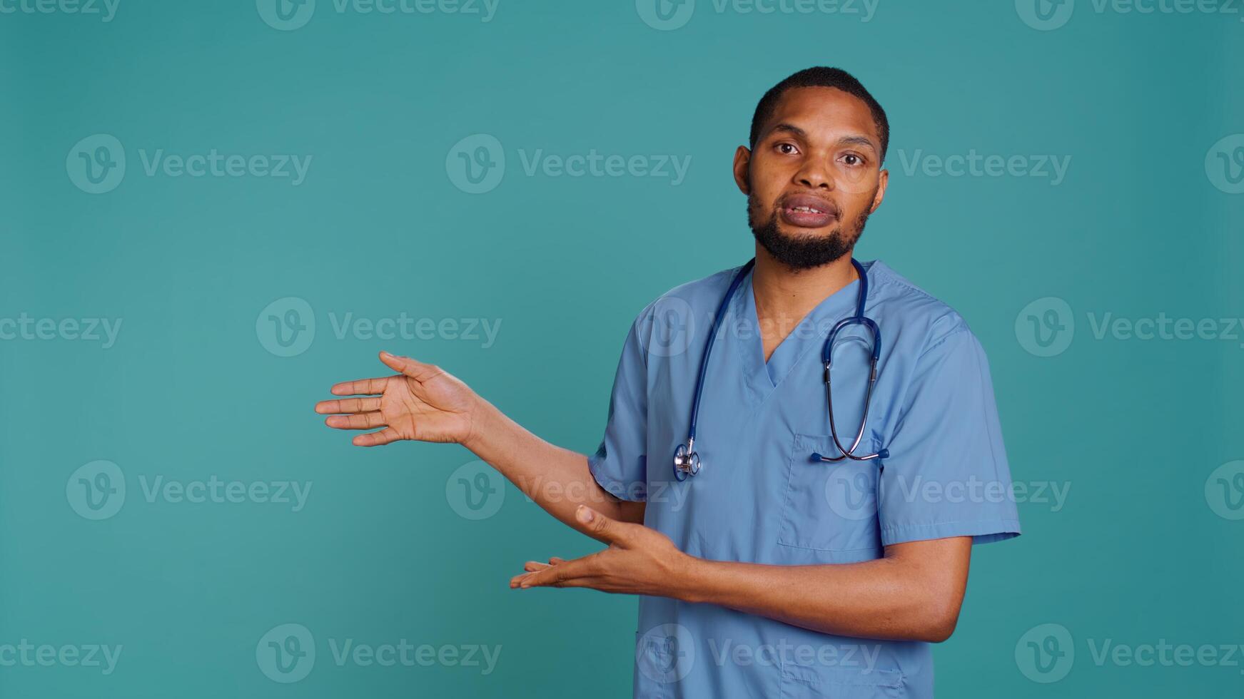 Portrait of african american nurse pointing hands towards empty space, doing advertising, talking with audience. Healthcare employee doing promotional ad, showing copy text, studio backdrop, camera B photo