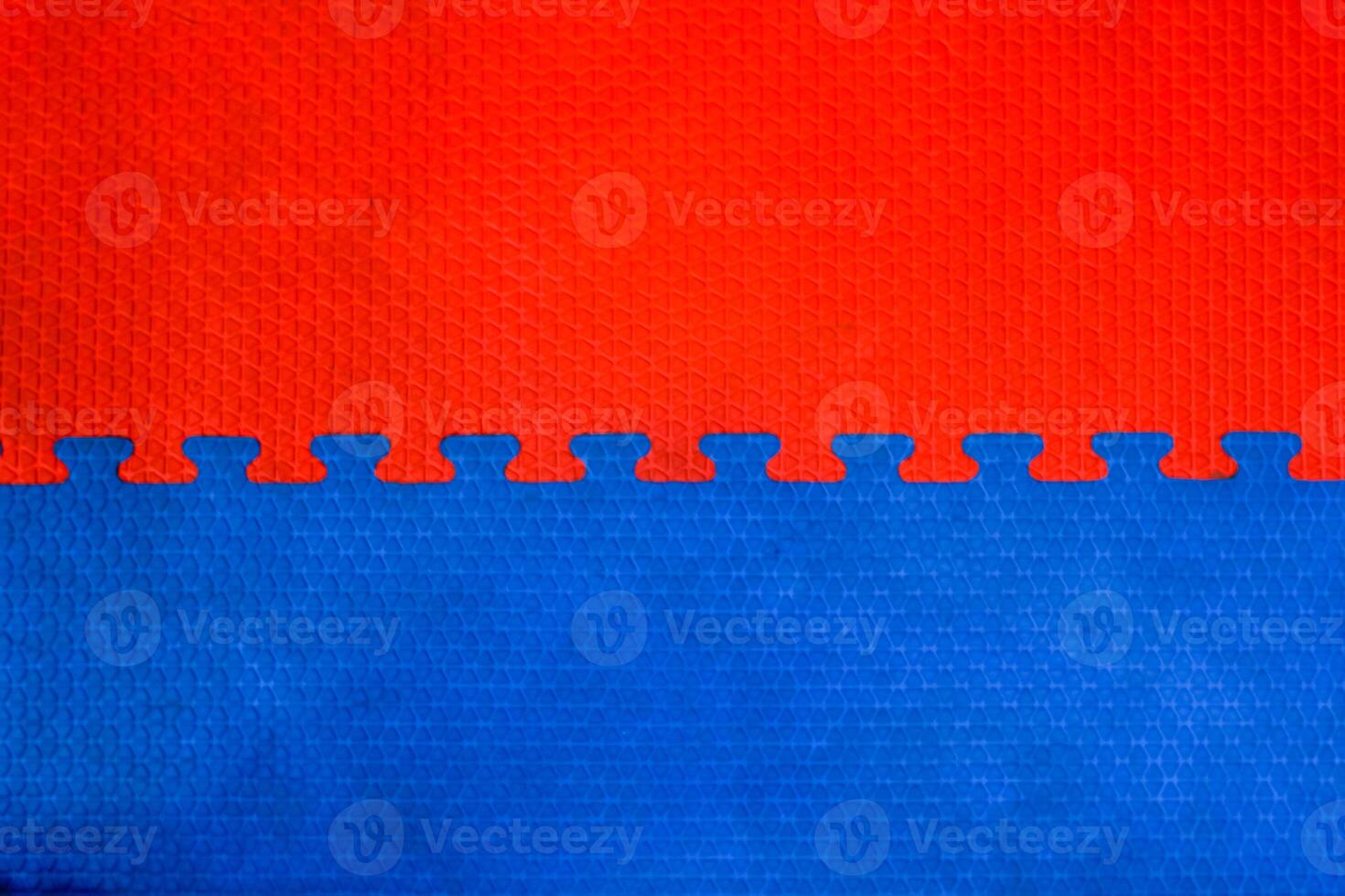 Easily interlocking puzzle shaped rubber floor mats to prevent falling shock hazards are widely used in gyms and children's rooms to prevent potential hazards. The background is a blank rubber bumper. photo