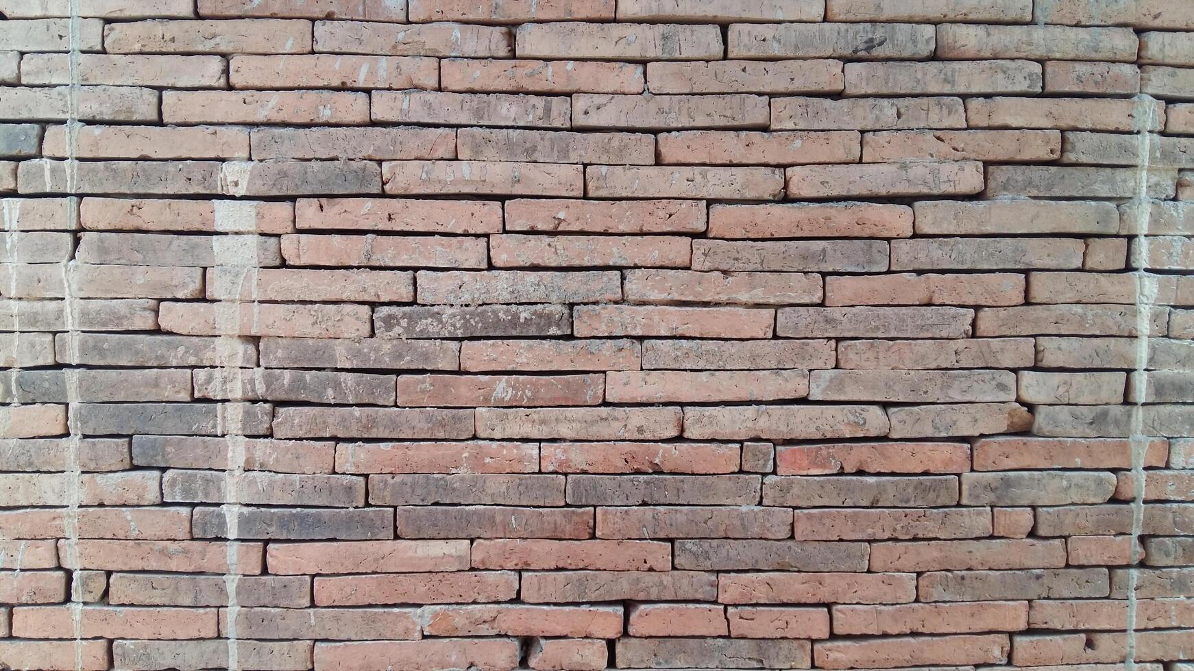 Brick wall background is a wall made of clay bricks, giving the structure strength and cement line between bricks that looks beautiful. It is popular to build a wall of ancient monuments.copy space, photo