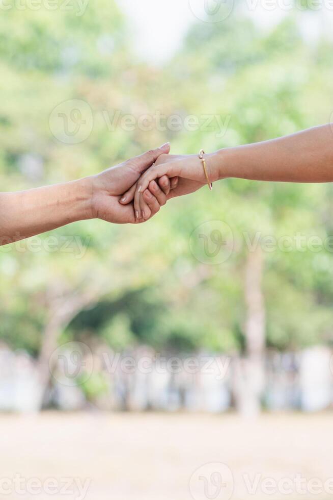 The Valentine couple are happily holding hands and taking a walk through the beautiful scenery of nature in the morning with love and care for each other. The concept of friendship, love and kindness photo