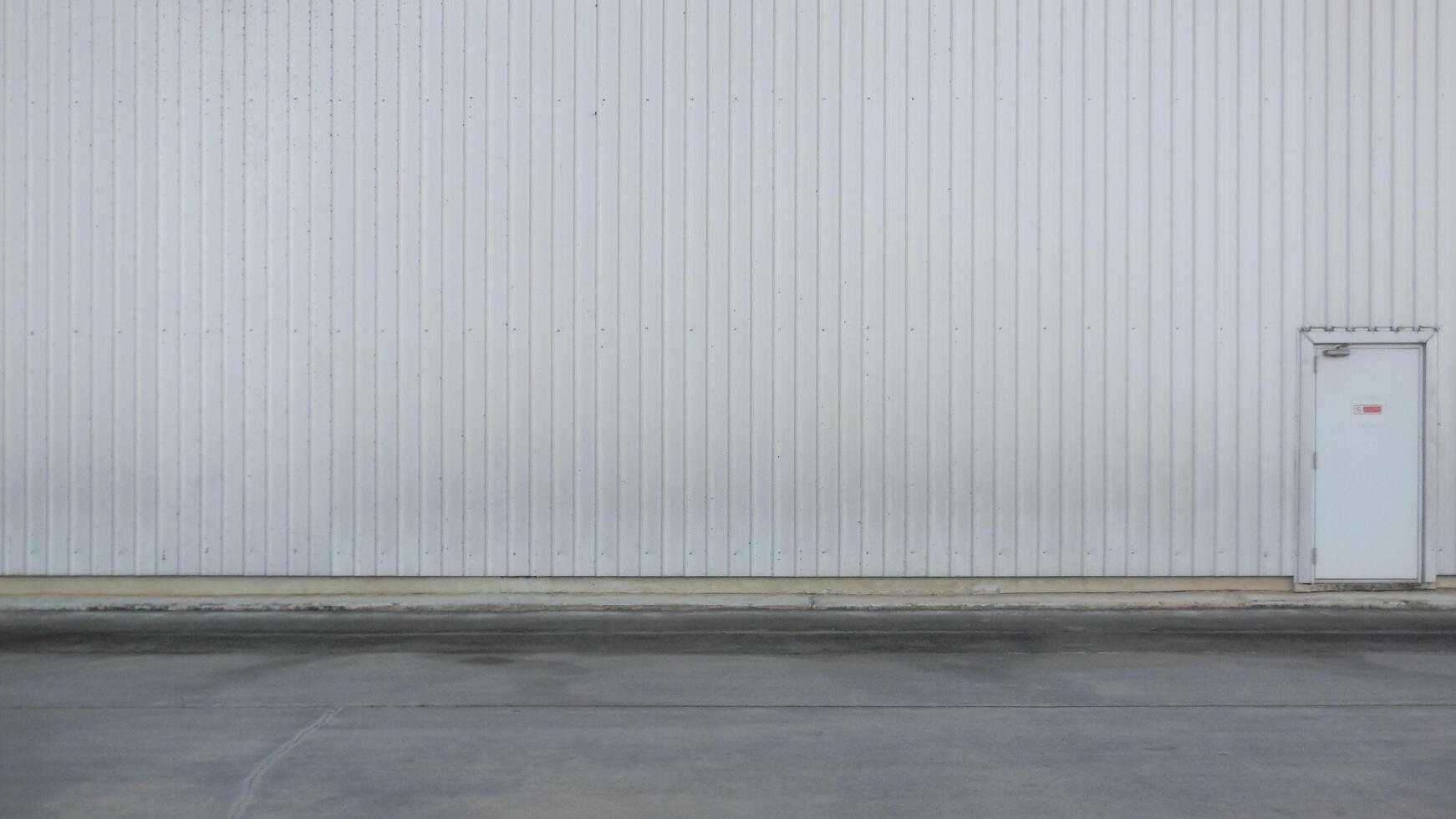 outer wall of a large warehouse with access doors for caregivers. The metal wall background of the spacious storage warehouse and caretaker entrance on the wall also provides space for messages. photo