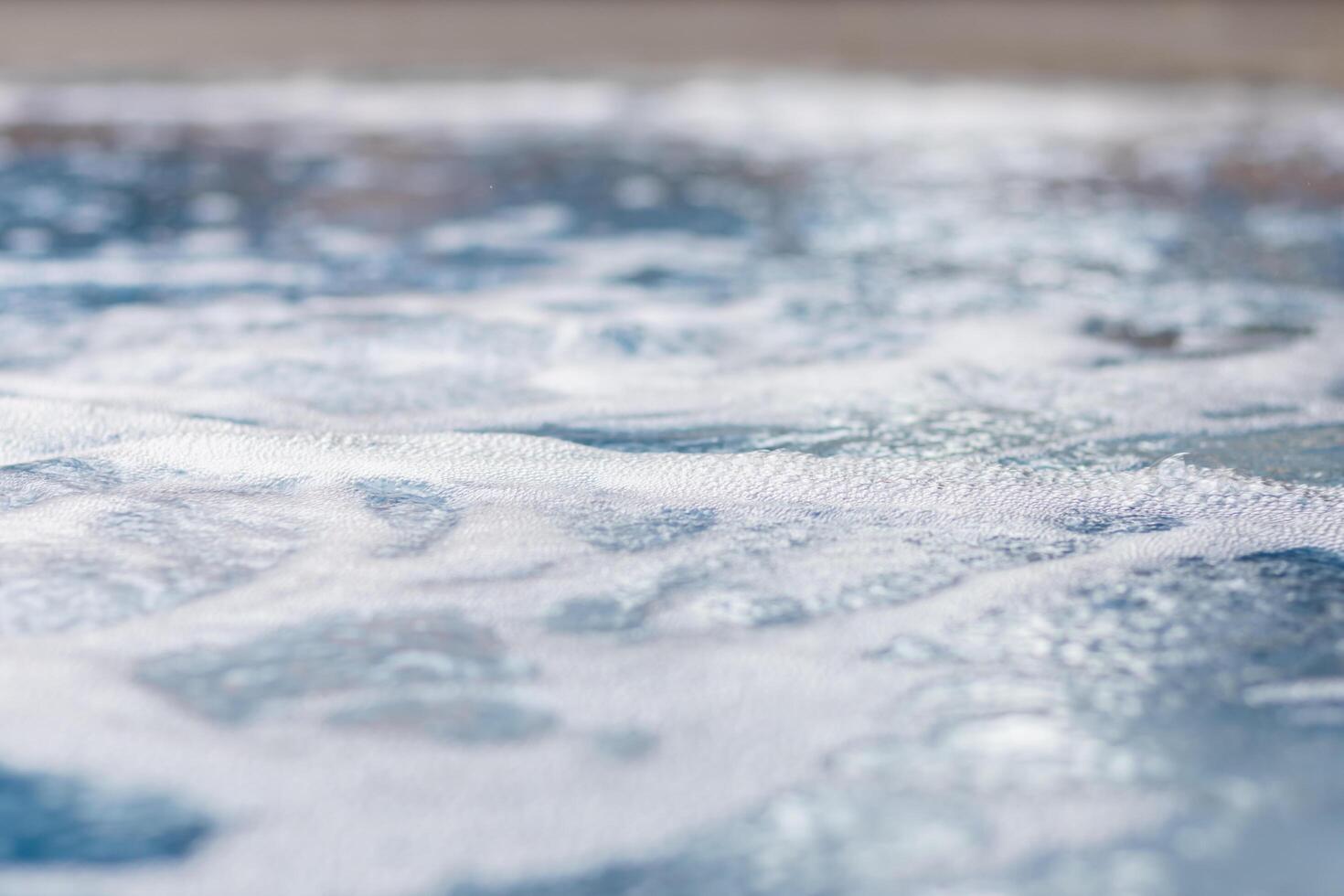 air bubbles ejected in water with a pressure generator inside the jacuzzi relax the body when immersed in the bath as it is a water pressure massage system. Bathtub Background with Copy Space photo