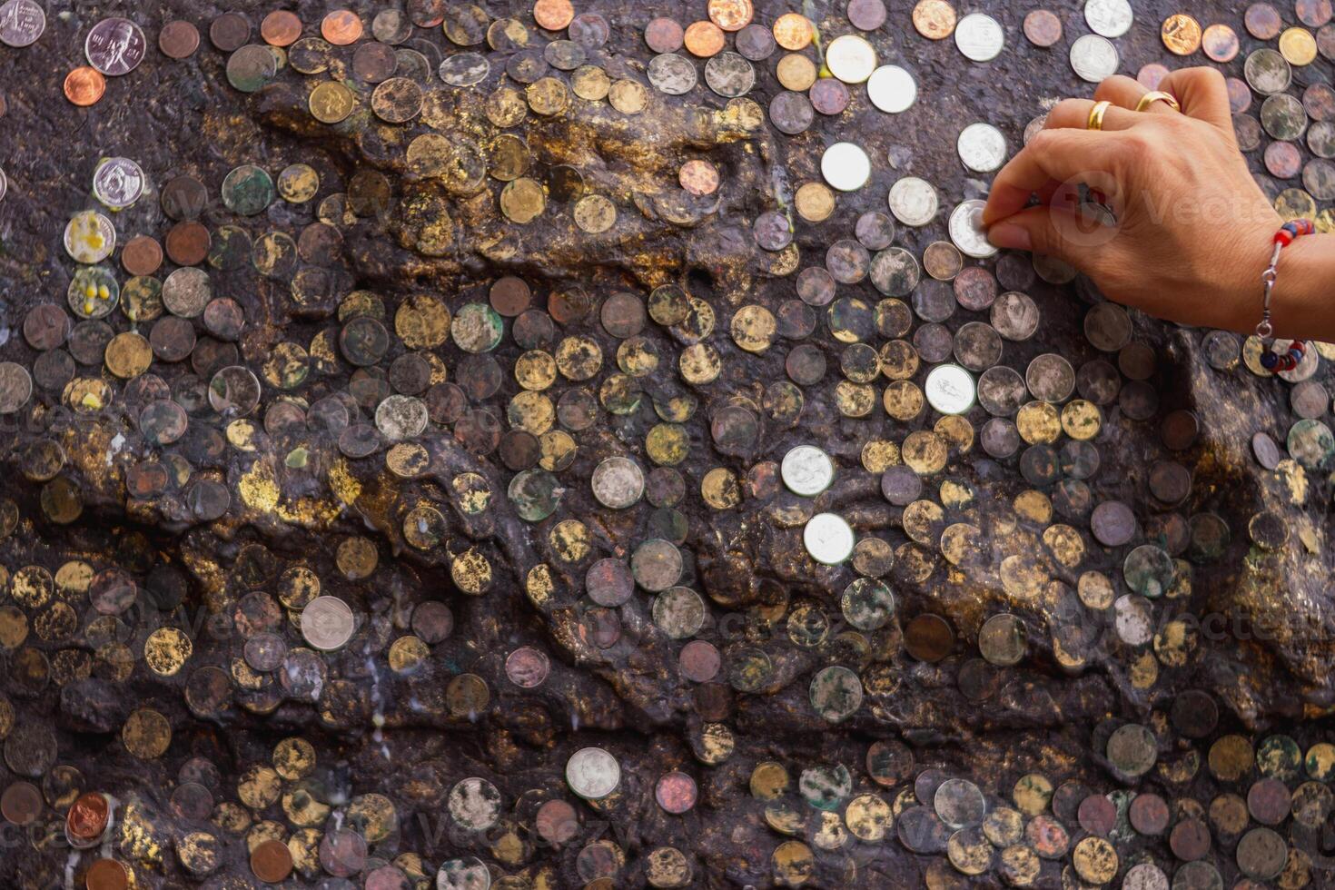 The blurry and dark background of the wall is adorned with international coins affixed to the walls of religious beliefs, and the medallions on the walls are also a blessing to God. photo