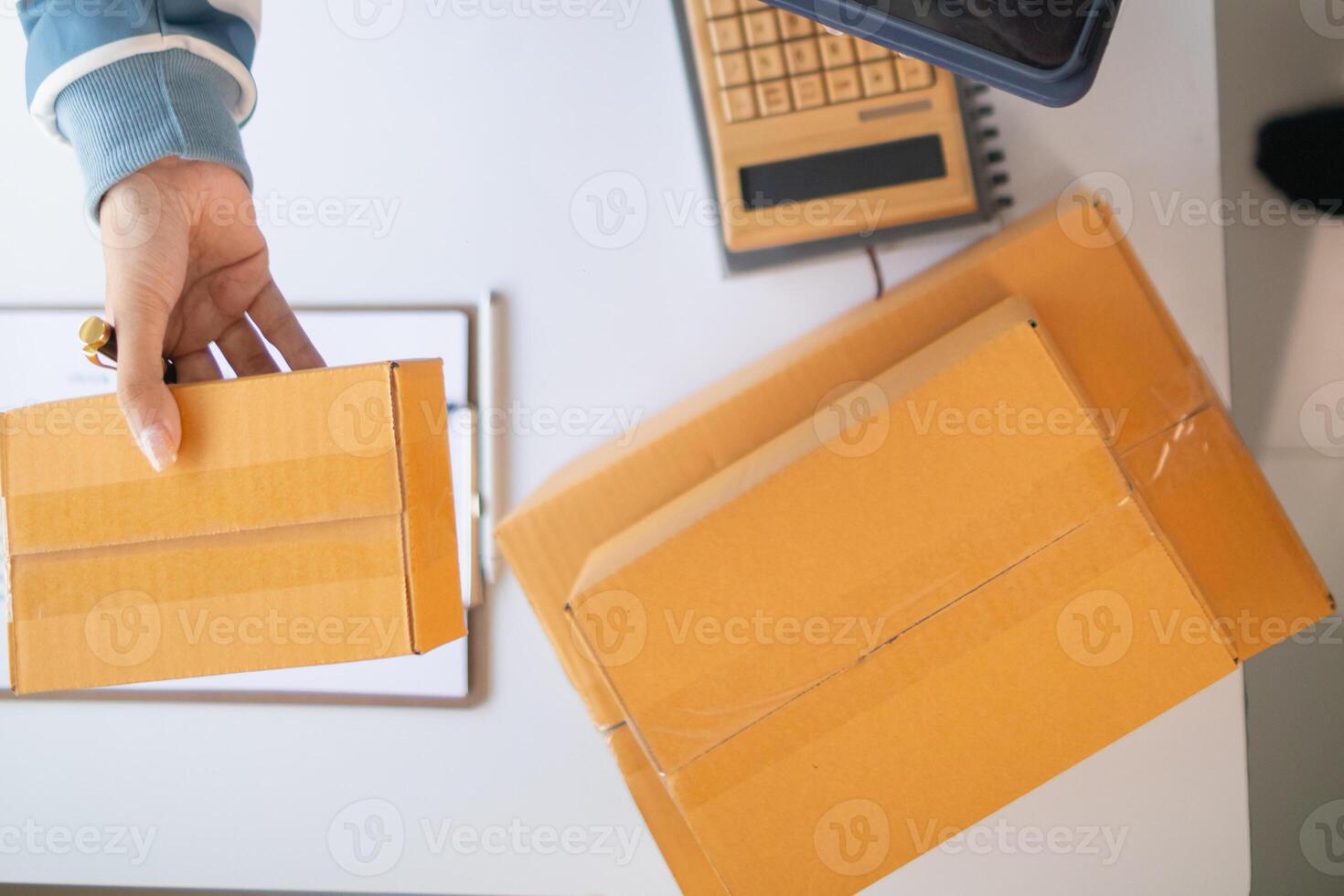 parcel boxes being packaged and ready to be sent to customers who have placed online orders within the online store's system. A small SME businessman has prepared the parcels and is ready for delivery photo
