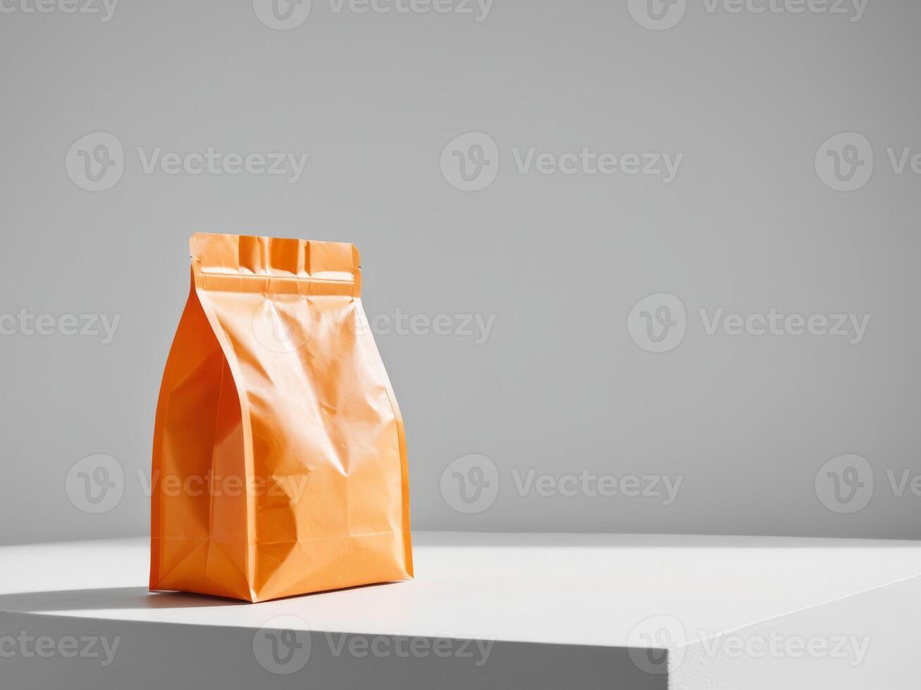 Orange paper doypack placed on podium on empty background. photo