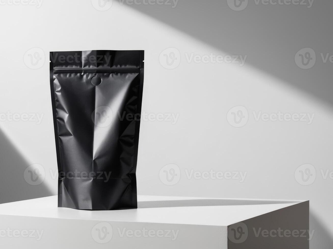 Black paper doypack placed on podium on empty background. photo