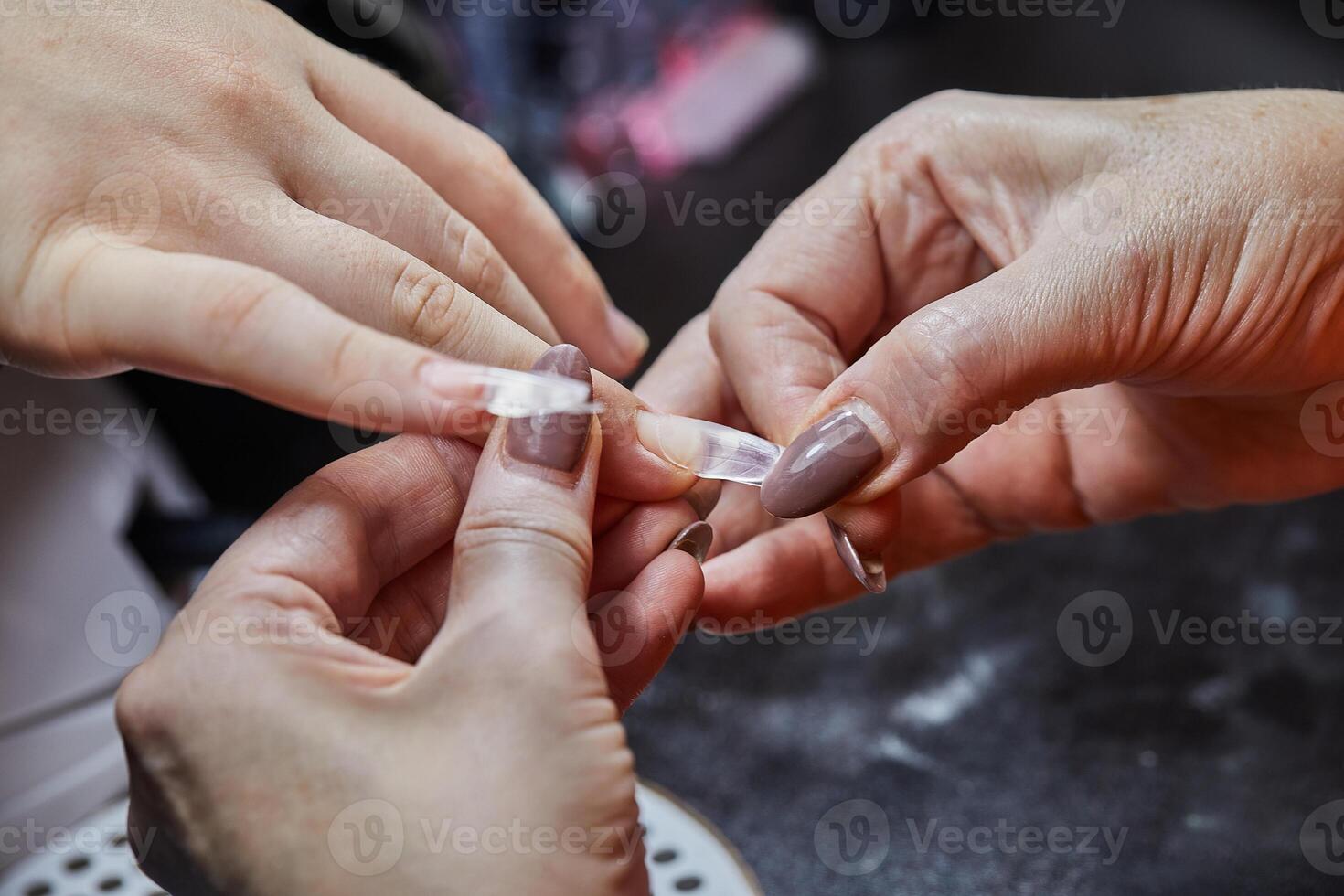 Nail Technician Applying Extension at Salon photo