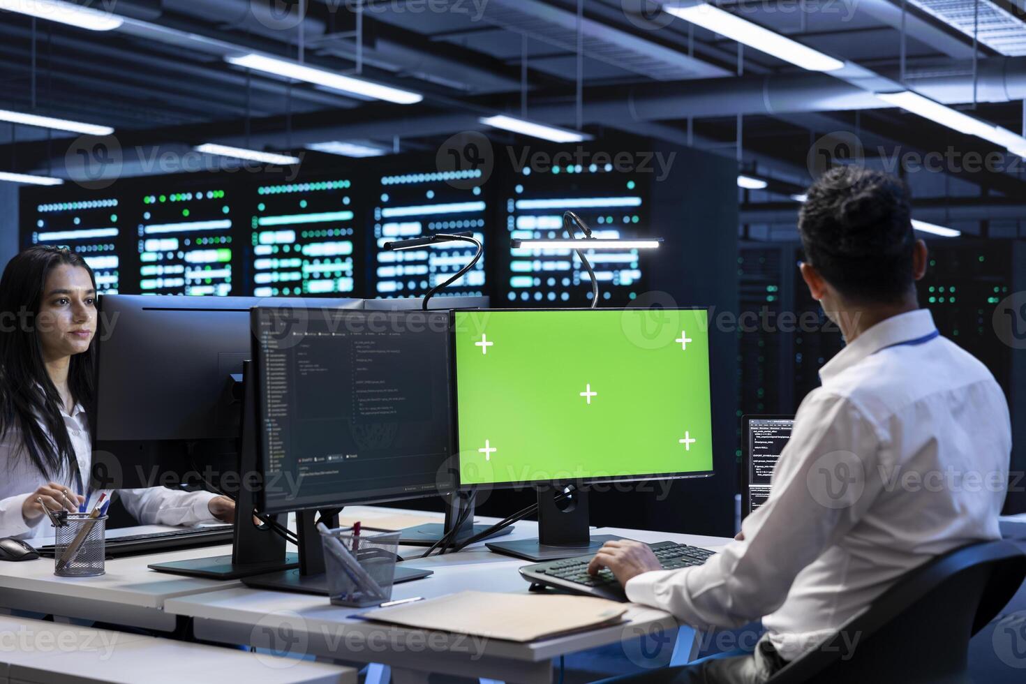 Admin coworkers using mockup computer monitor to check server clusters configuration settings. Professionals checking event logs in monitoring software on chroma key PC in data center photo