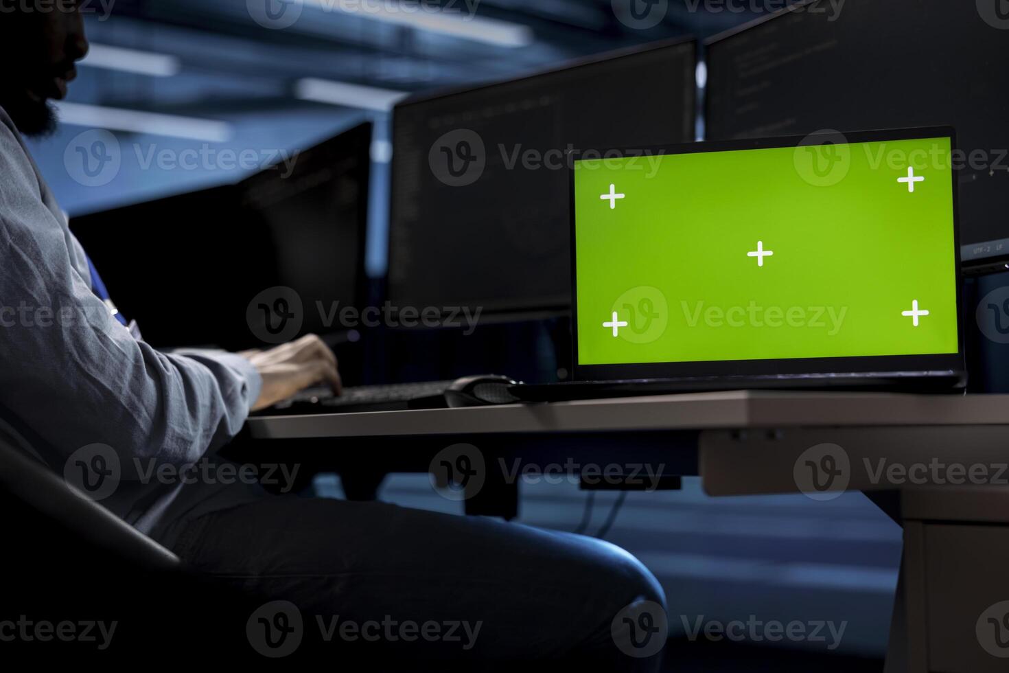 Engineer in server hub using isolated screen laptop to repair equipment storing datasets. Professional using chroma key notebook to do debugging on rigs doing computational operations photo