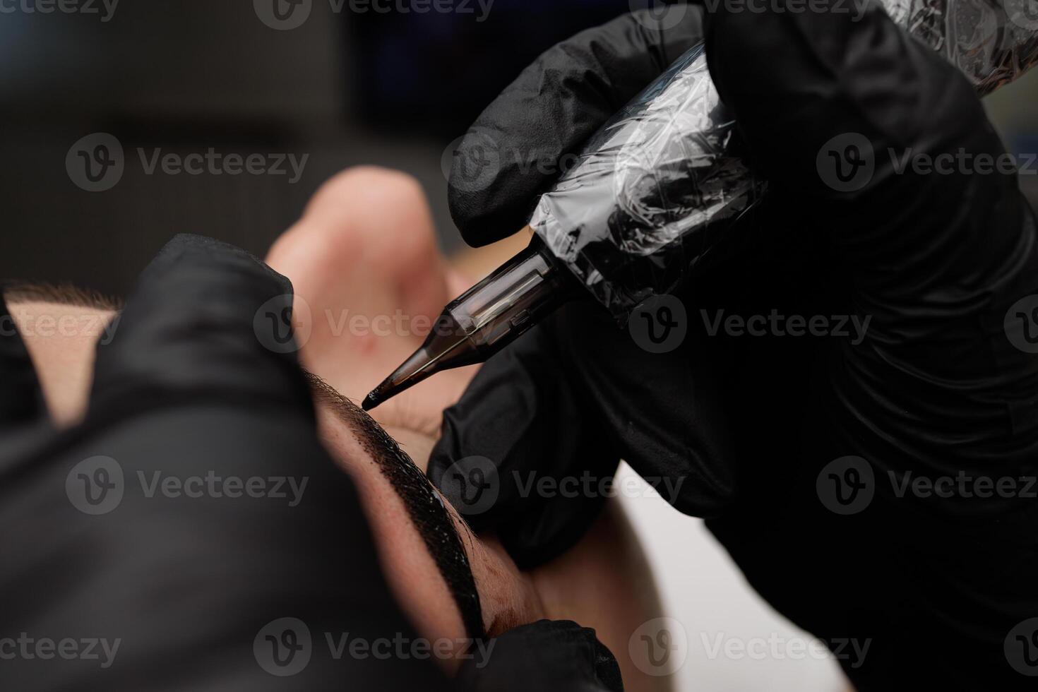 The procedure of permanent eyebrow makeup close-up spout of the cartridge from the machine for tattooing. Permanent eyebrow makeup PMU for brunettes photo
