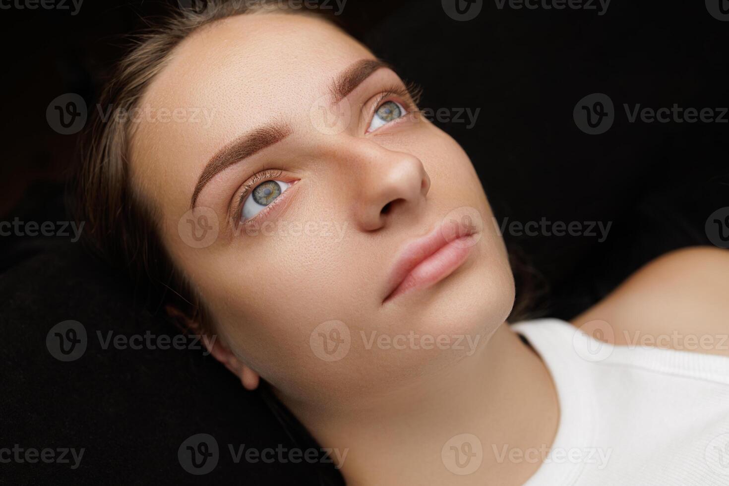 Eyebrows of a brunette woman with permanent eyebrow makeup done. Permanent eyebrow makeup PMU for brunettes photo