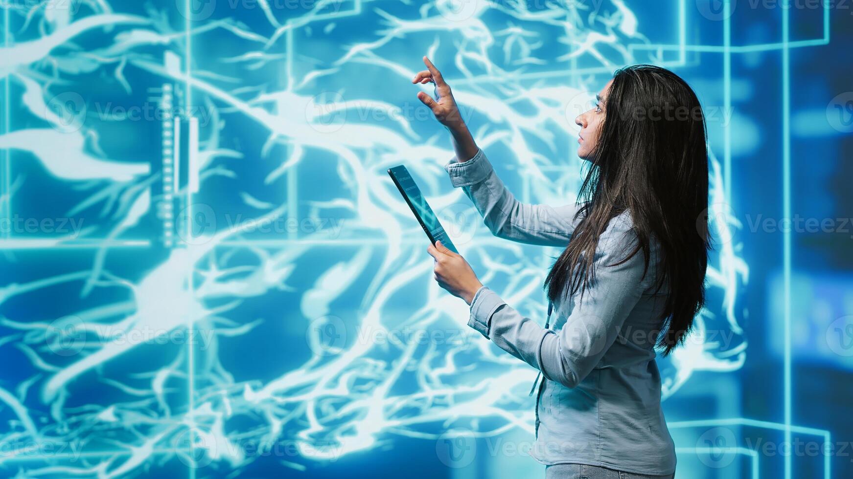 Computer scientist using artificial intelligence computing simulating human brain thought processes. Indian employee working on tablet, developing AI machine learning algorithms, camera A photo