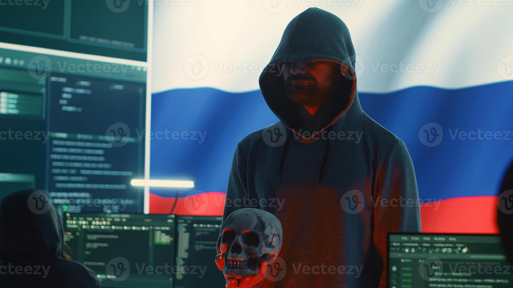 Digital outlaw hacker in a dark hood issuing cyber threats with a human skull to make death threats, aggressive malicious intent. Russian man committing cybercrime and scamming nations. Camera A. photo